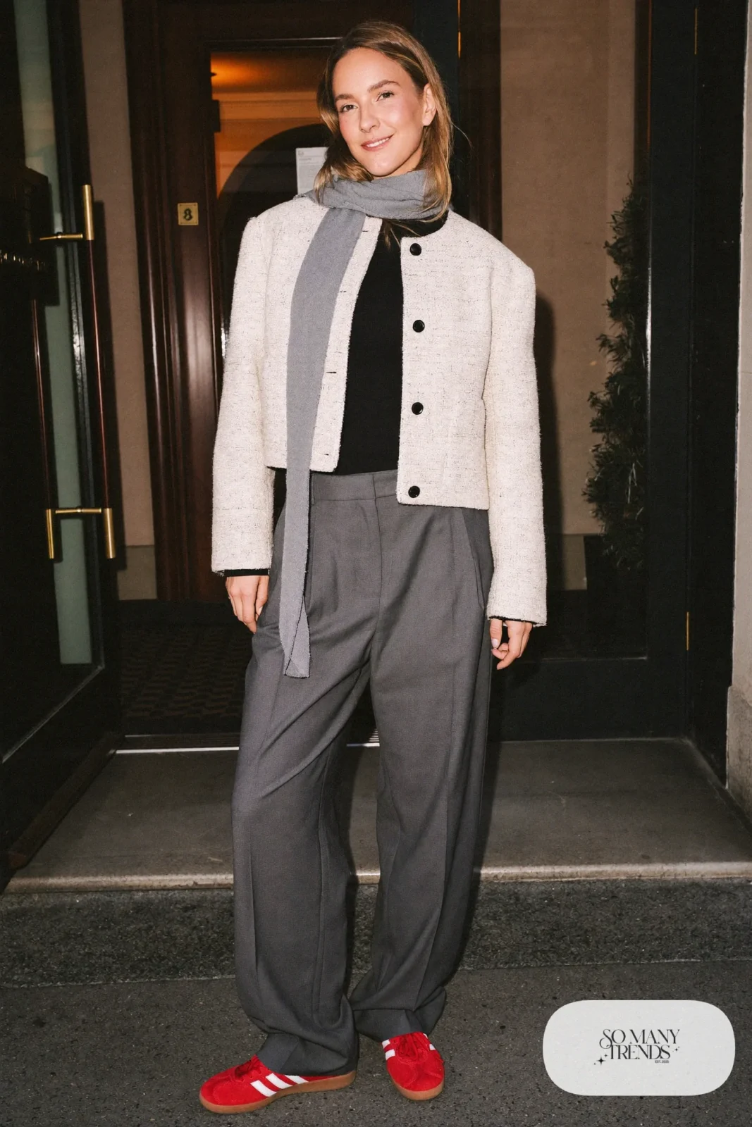 Woman in a cropped cream tweed jacket, high-waist gray wide pants, thin scarf and red Adidas Gazelle sneakers, outfit 22