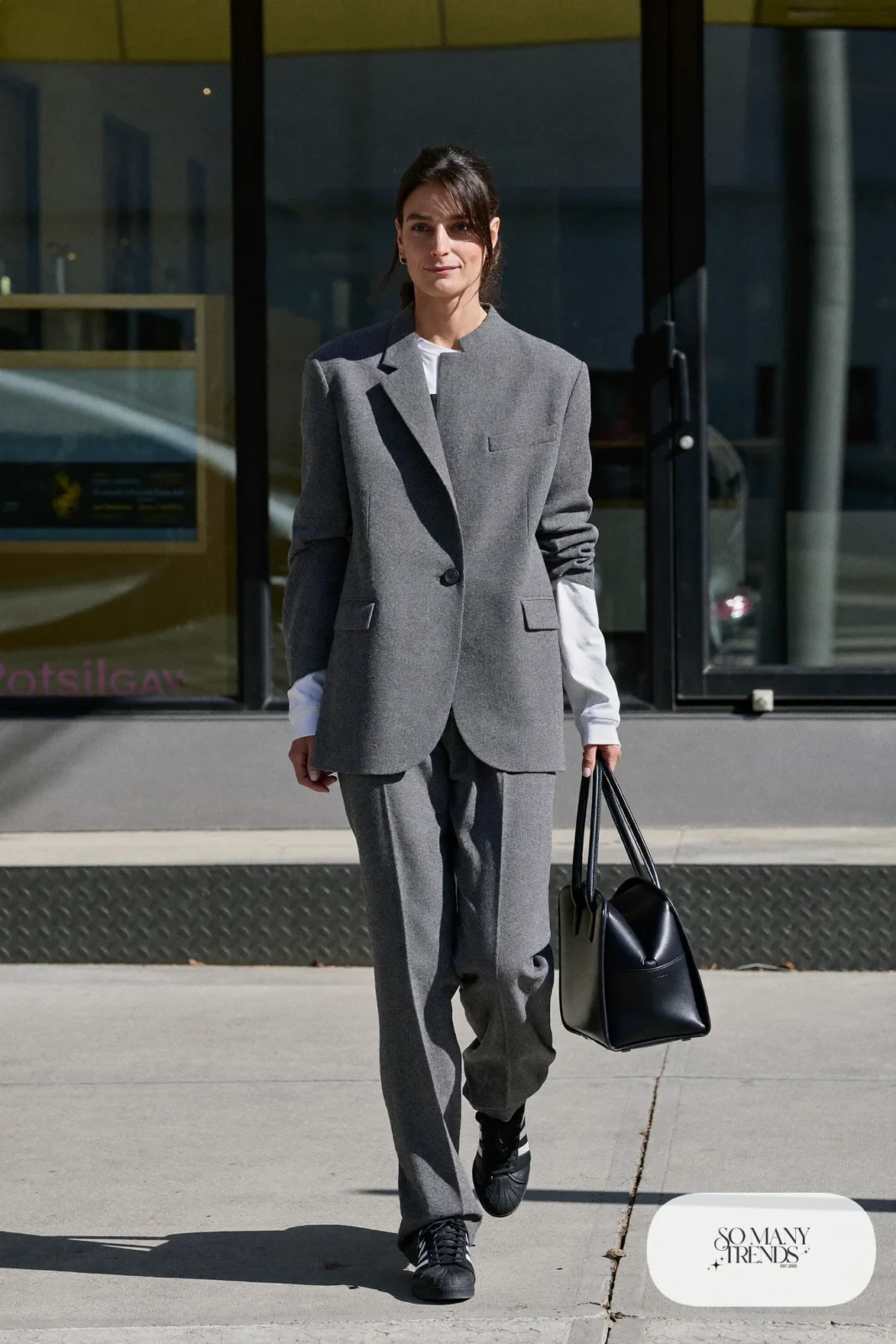 Woman in gray wool blazer and matching straight pants, white tee and black Adidas Campus sneakers, outfit 11
