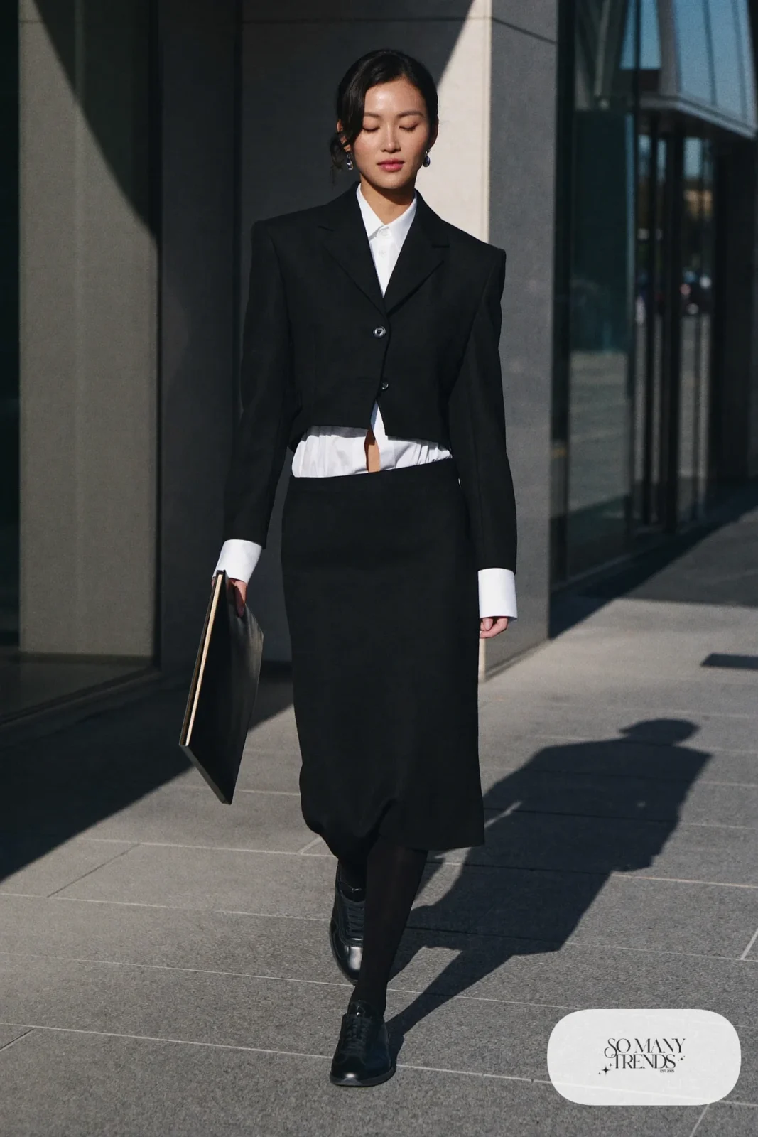 Woman in black wool cropped blazer and midi skirt set, white shirt, black tights and black Adidas Campus sneakers, outfit 25