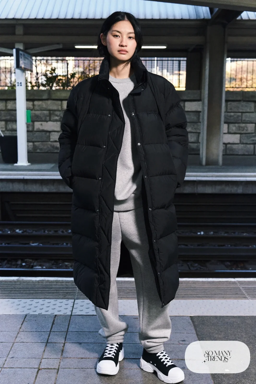 Woman in a long black puffer coat, gray sweatshirt, straight gray sweatpants and black Converse Run Star Hike platform sneakers - outfit 11