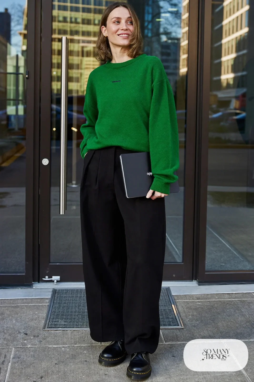 Woman in emerald fine-knit sweater, black pleated wide pants and black Doc Martens boots, outfit 3