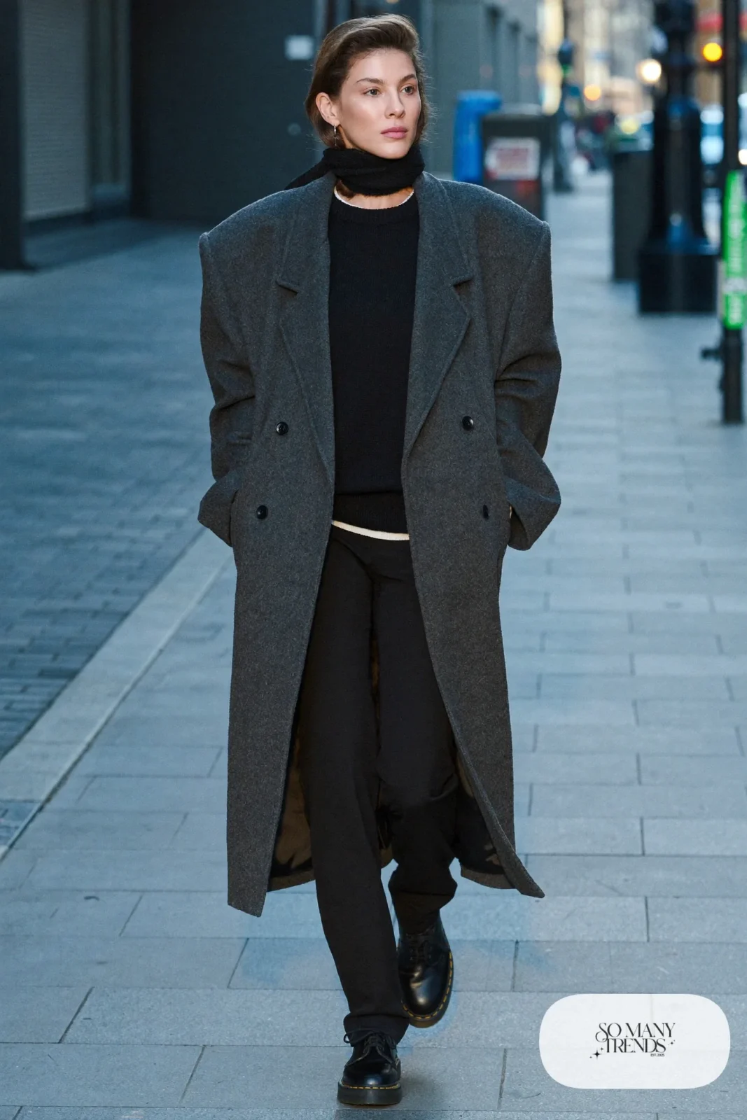 Woman in oversized gray wool coat, black turtleneck-free knit, black pants and black Doc Martens loafers, outfit 18