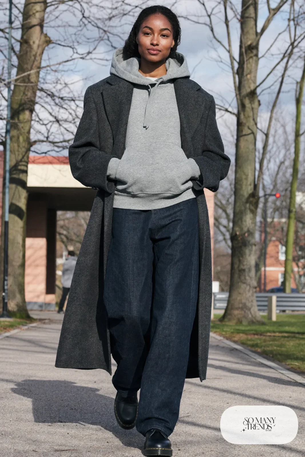 Woman in gray hoodie, long charcoal wool coat, dark straight jeans and black Doc Martens boots, outfit 26