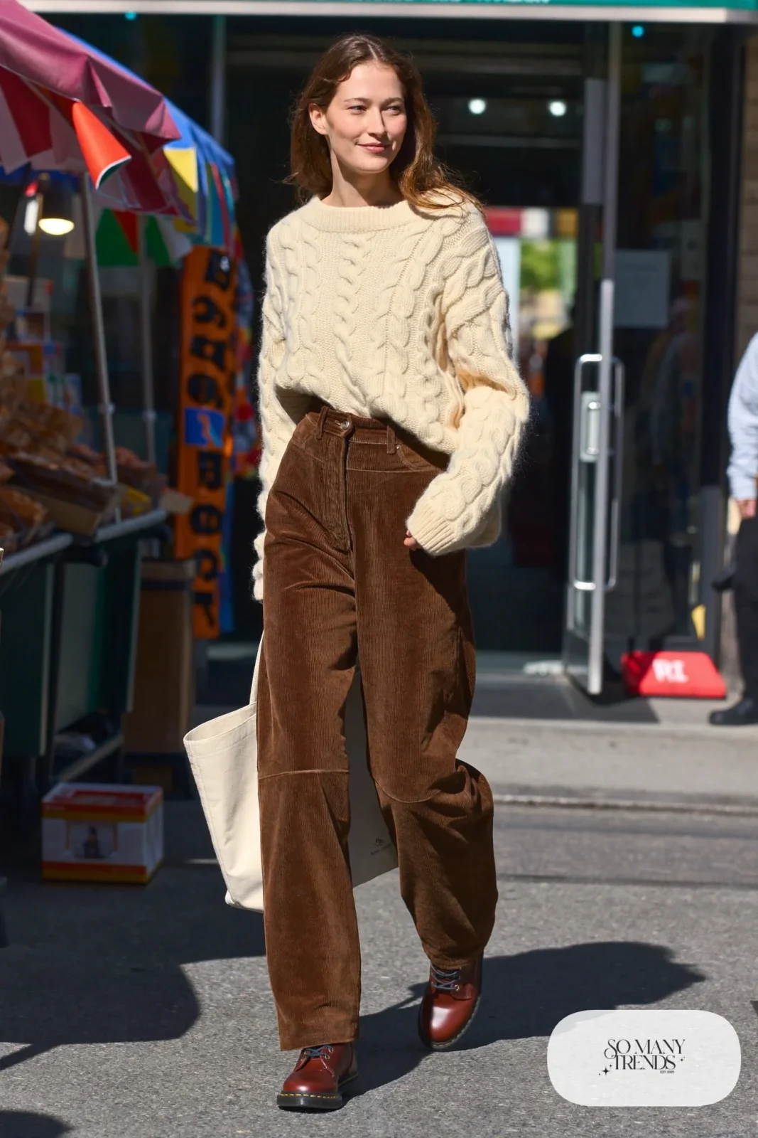 Woman in cream cable-knit sweater, brown wide corduroy pants and cognac Doc Martens boots, outfit 27