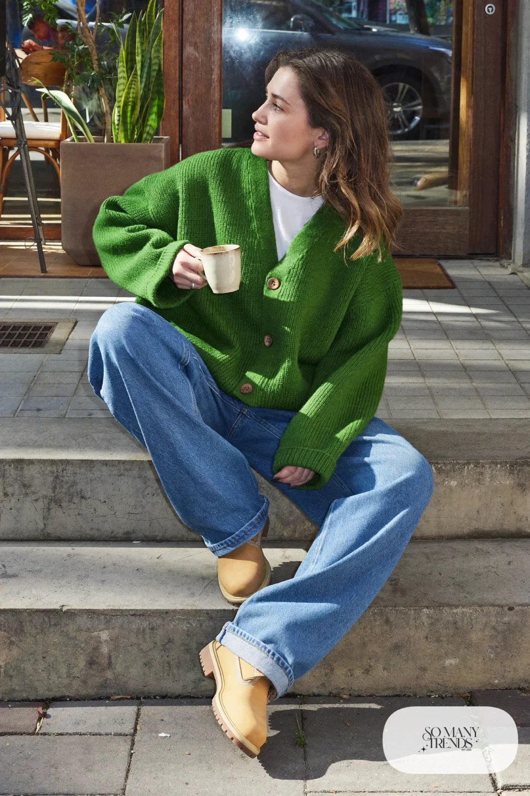 Woman in forest green chunky cardigan, white tee, barrel-leg jeans and wheat Timberland-style boots, outfit 5