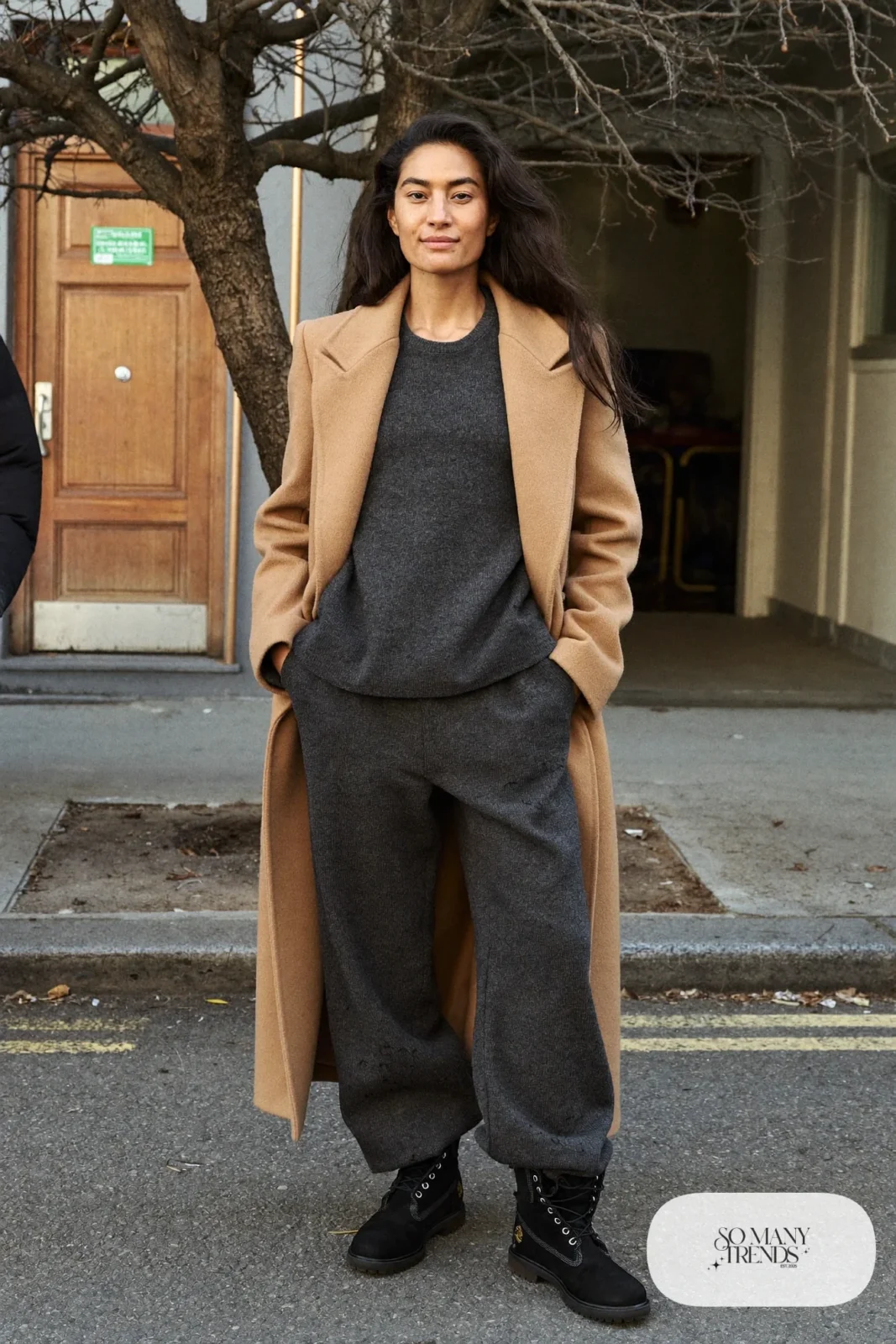 Woman in charcoal knit sweater and wide-leg knit pants set, camel coat and black Timberland-style boots, outfit 16