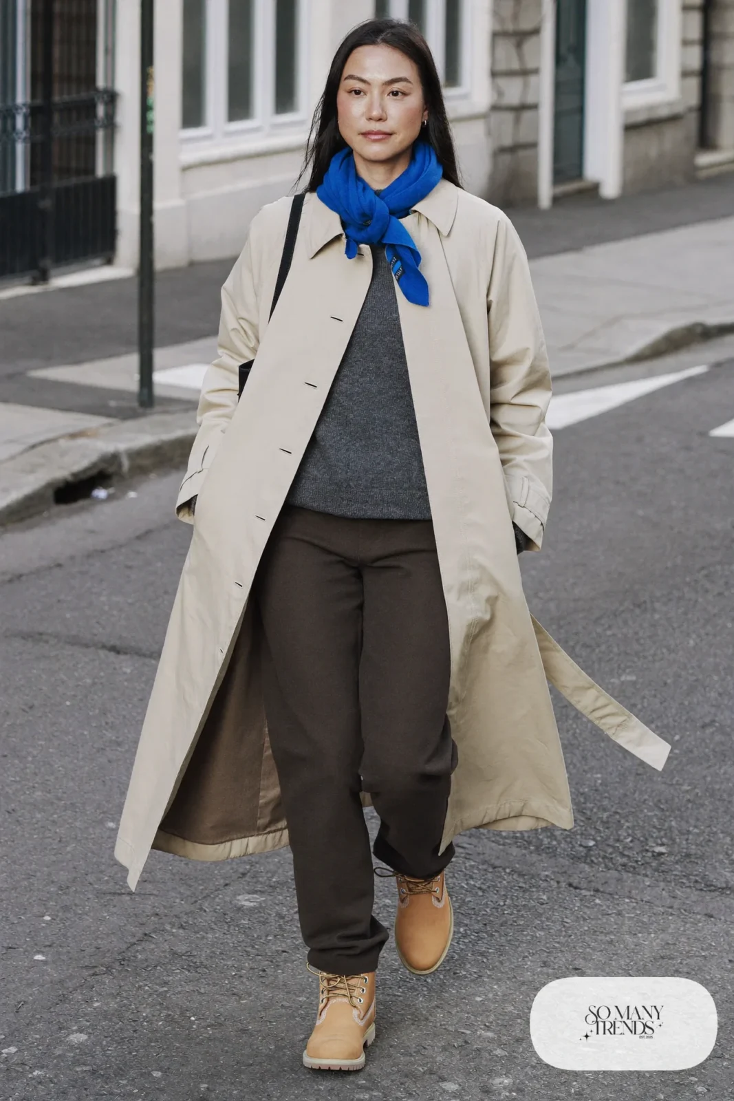 Woman in beige trench coat, charcoal sweater, charcoal pants and wheat Timberland-style boots, outfit 22