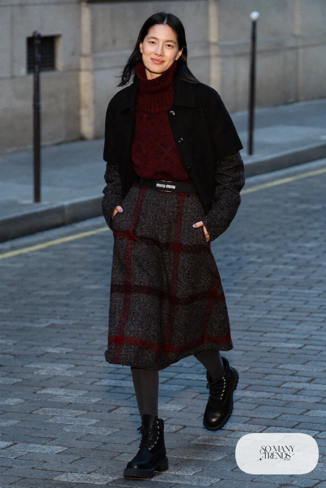 Woman in charcoal tweed skirt, burgundy turtleneck, charcoal tights and black Timberland-style boots, outfit 23
