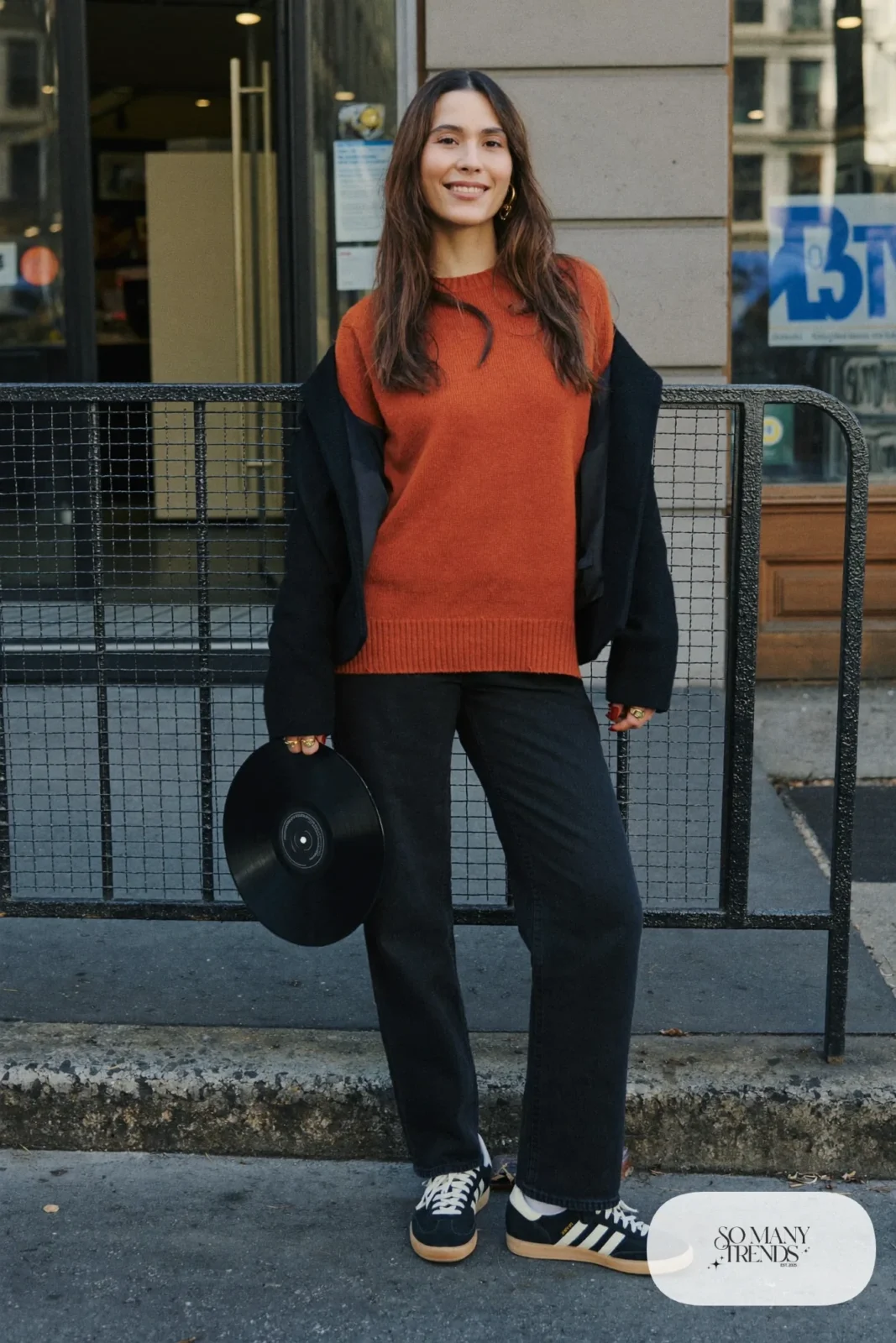 Burnt orange knit sweater, black straight jeans, black wool coat and low retro sneakers, outfit 6