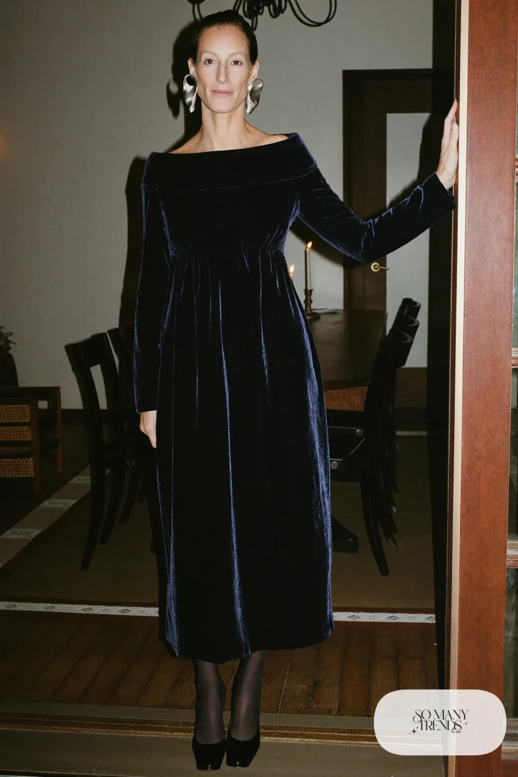 Woman in a black velvet long sleeve dress with large silver earrings and black pumps, New Year's Eve outfit 14