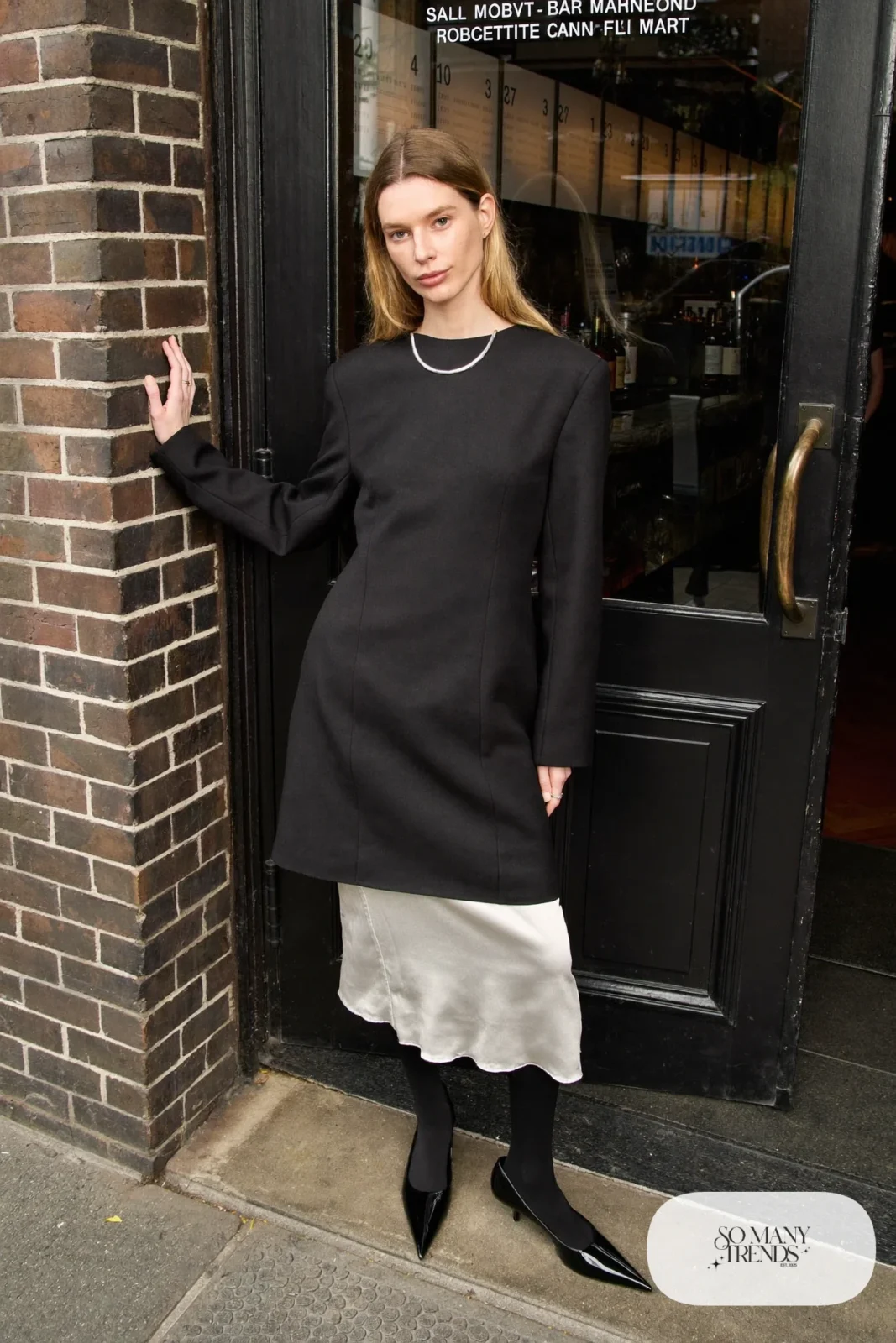 Woman in a sheer black long sleeve dress over a silver satin slip with black pumps, New Year's Eve outfit 16