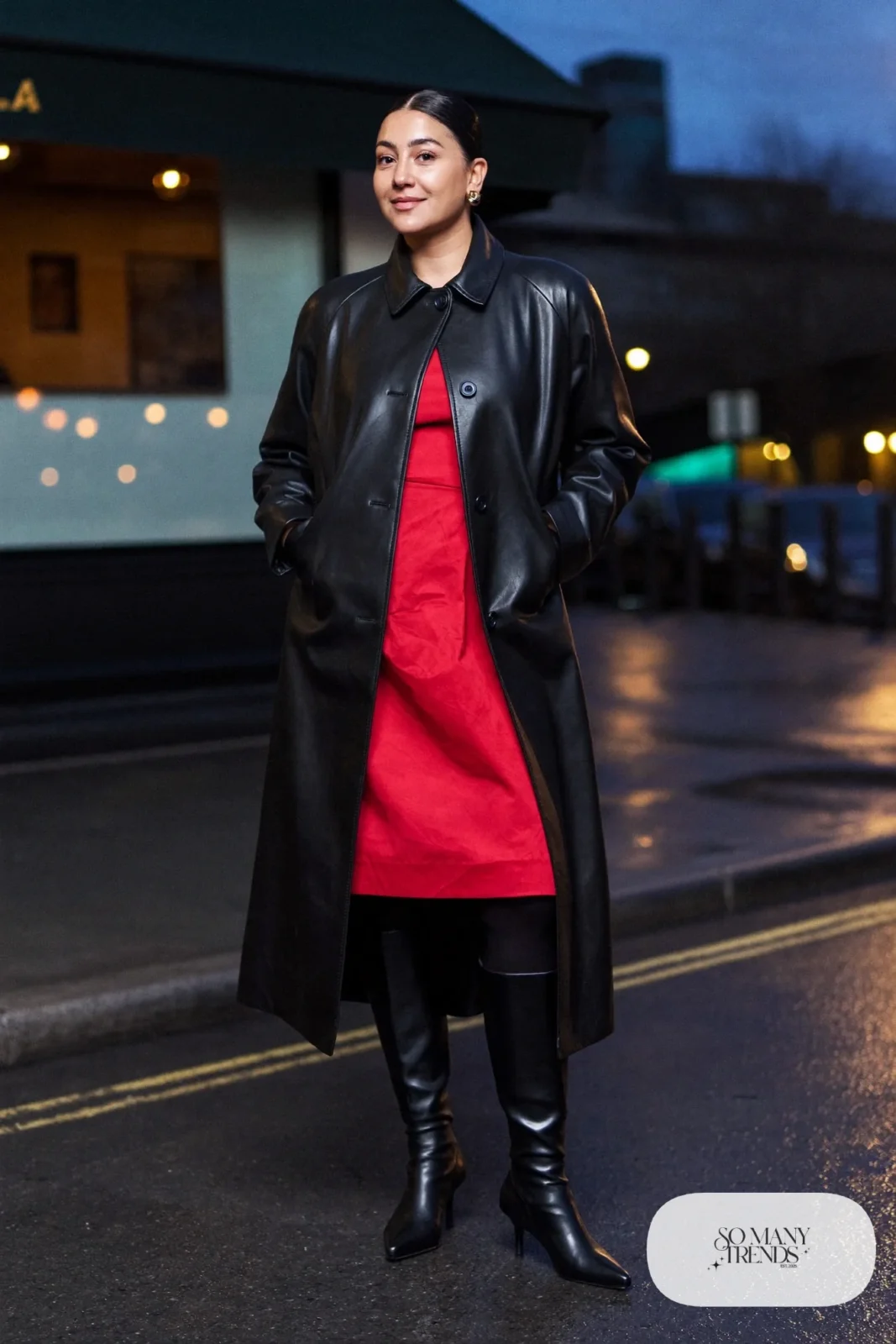Woman in a red midi dress, long black leather trench coat and black heeled boots, look 12