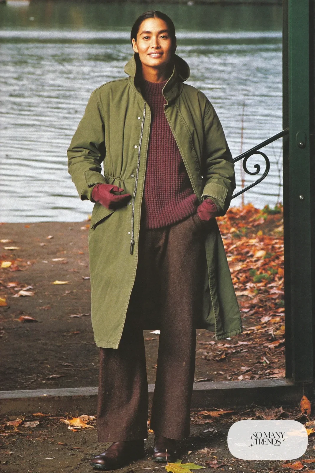 Woman in an olive parka, burgundy knit, wide brown pants, boots and burgundy gloves, outfit 12