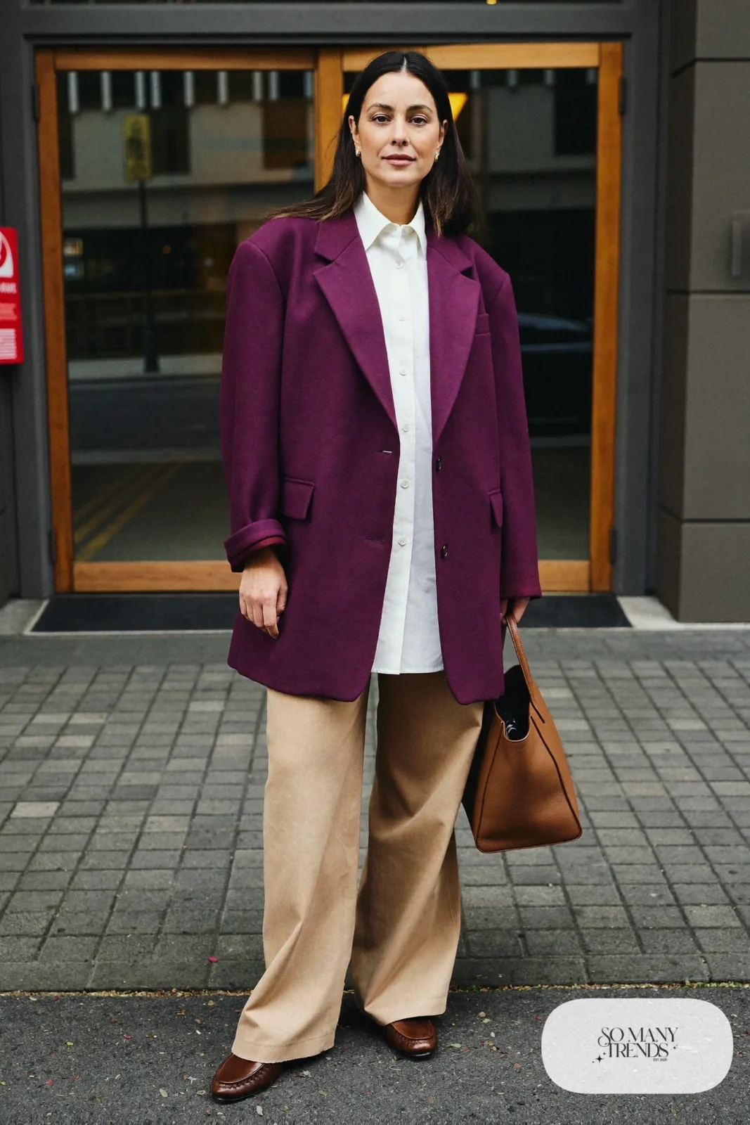 Woman in an eggplant oversized blazer, ivory cotton shirt, tan wide-leg pants and brown leather loafers, outfit 3