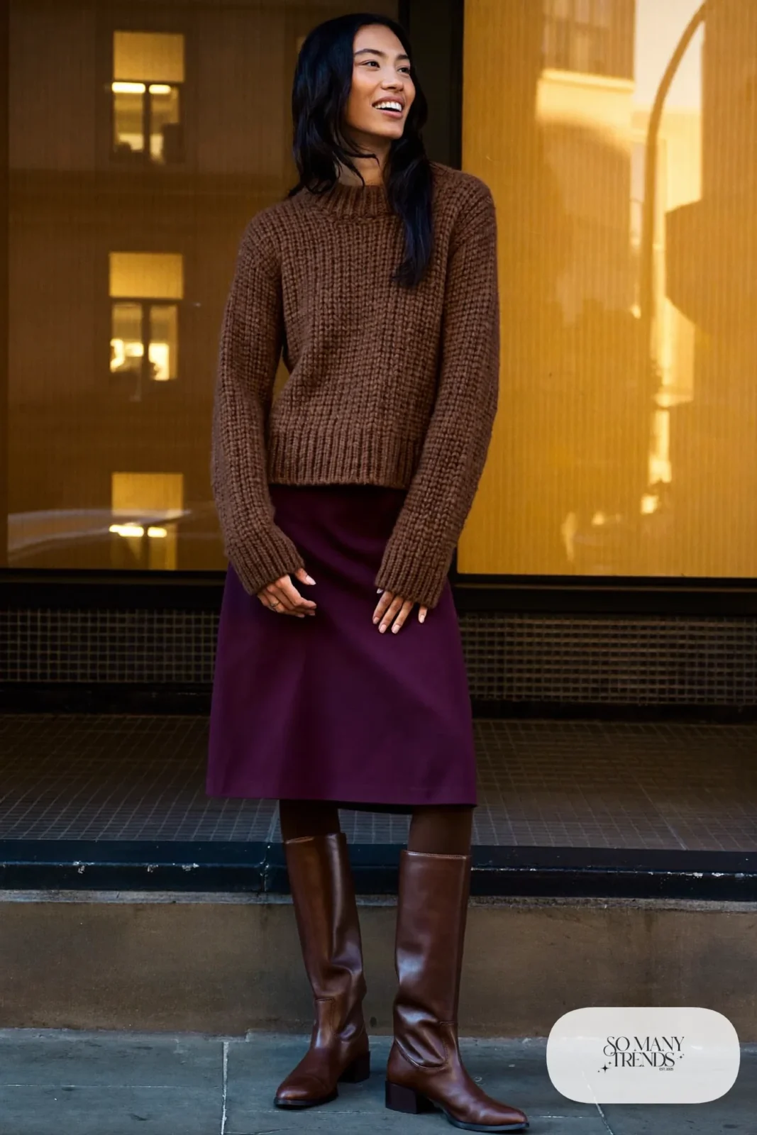 Woman in a plum midi skirt, chocolate chunky knit sweater, sheer black tights and brown lug-sole boots, outfit 11