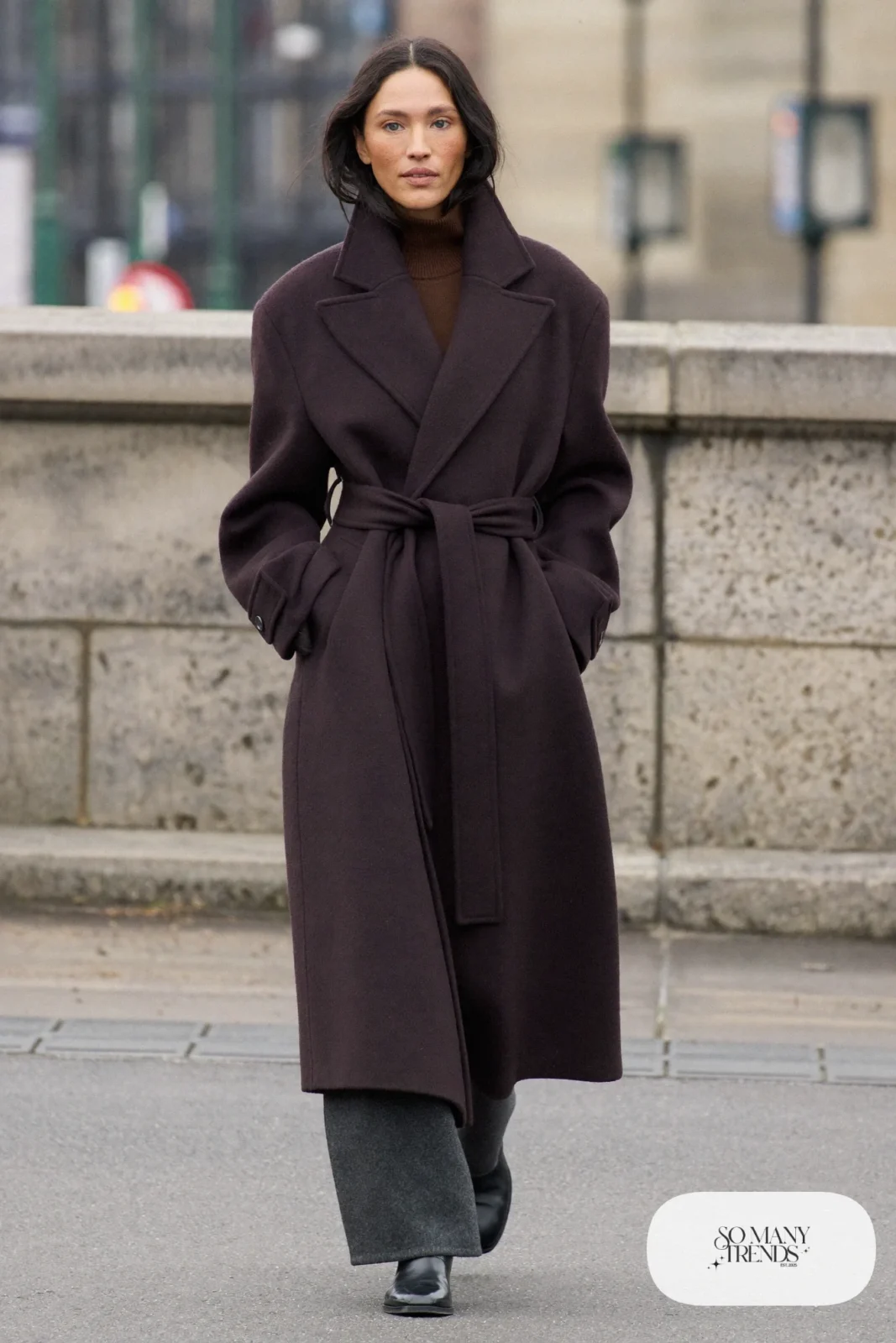 Woman in a plum wool wrap coat, chocolate brown turtleneck, charcoal gray wide-leg pants and black leather boots, outfit 26