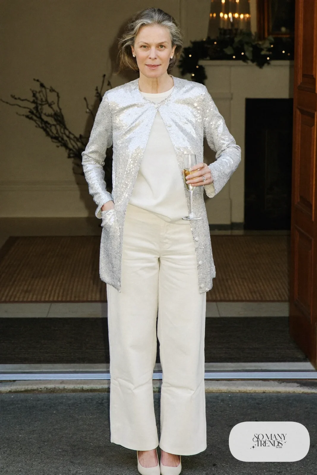 Woman over 50 in a silver sequin cardigan, ivory tee, ivory wide-leg pants and nude pumps, Christmas outfit 15