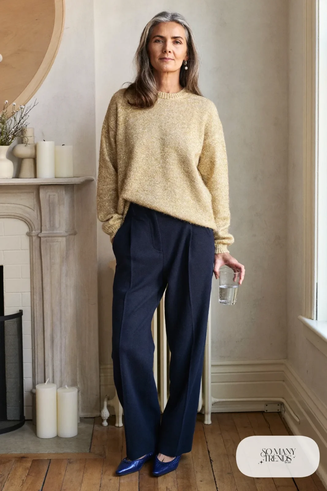 Woman over 50 in a champagne metallic knit sweater, navy straight-leg pants and navy pointed flats, Christmas outfit 24