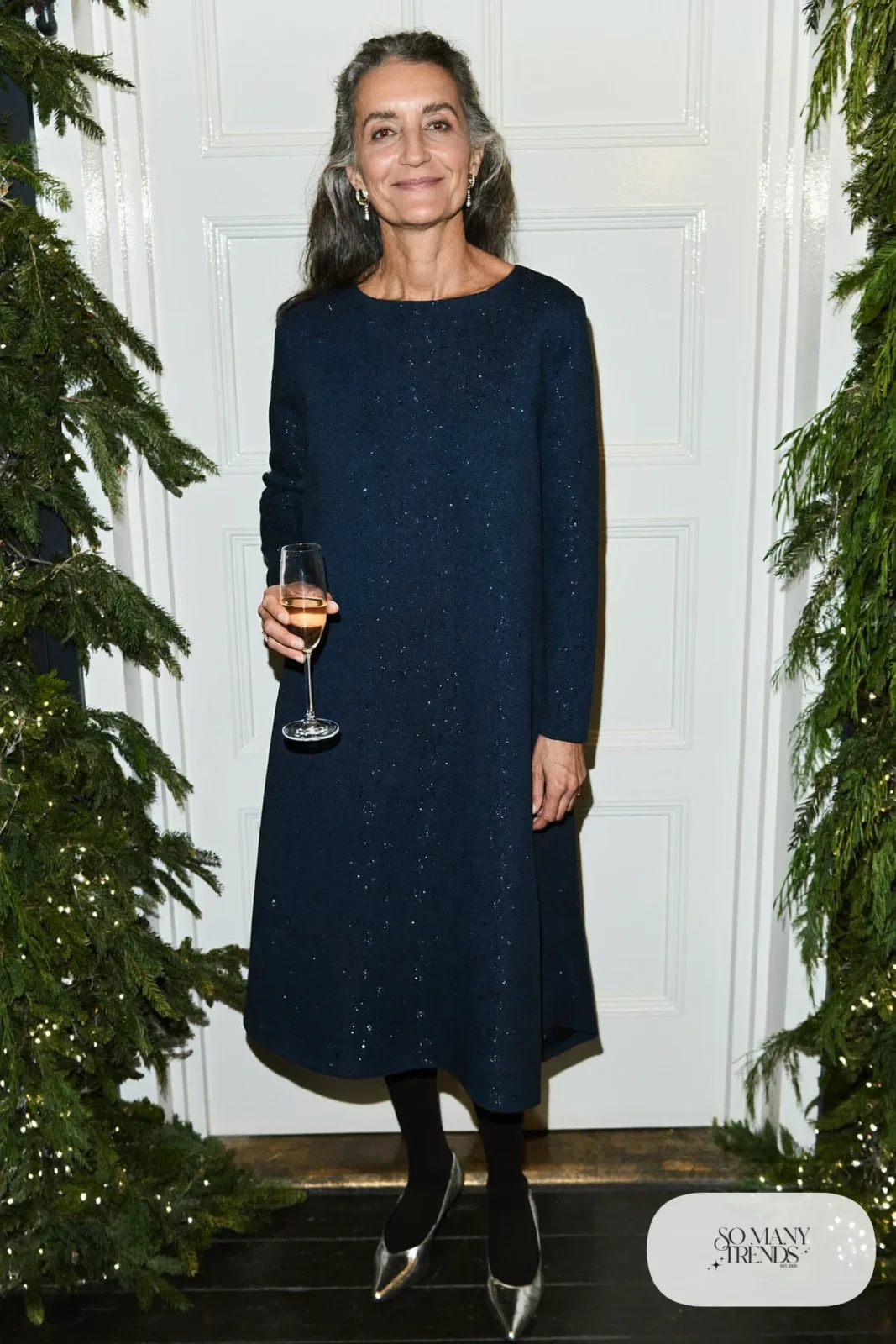Woman over 50 in a navy sparkle midi dress, silver pumps and sheer tights, Christmas outfit 26