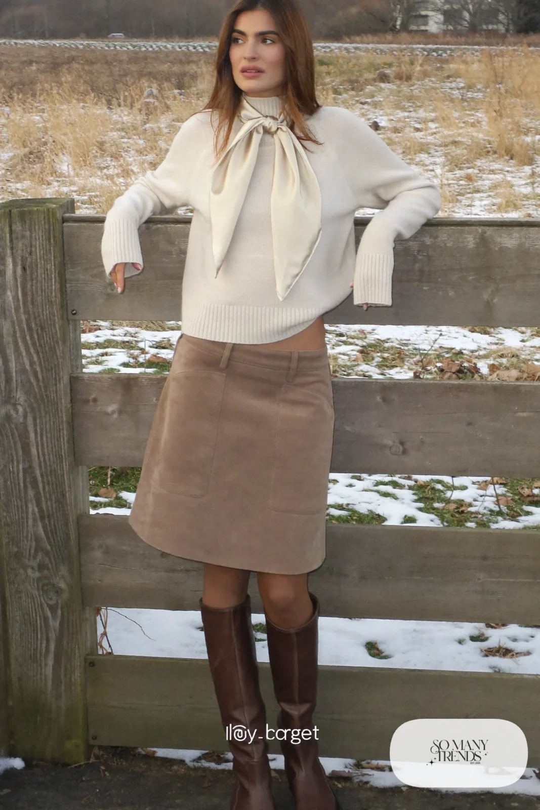 Woman in a taupe suede A-line skirt, cream knit, brown tights and tall brown boots, outfit 8