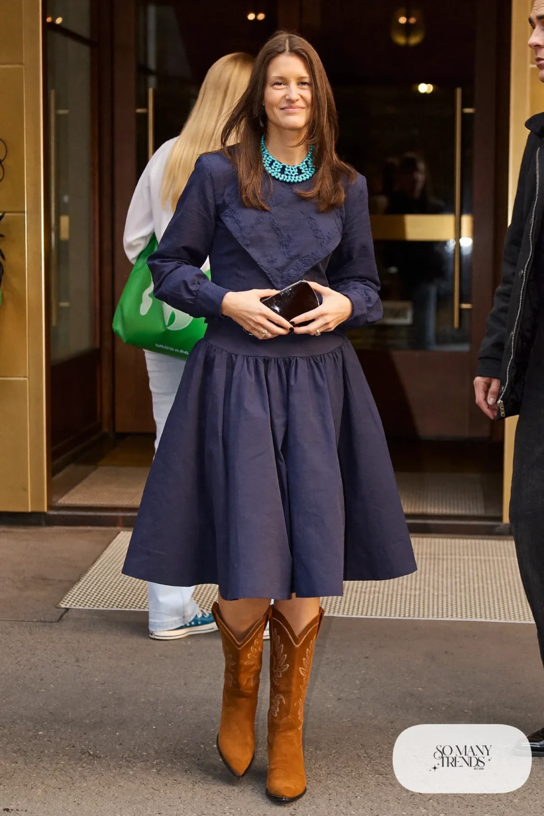 Woman in navy western yoke fit-and-flare dress, turquoise necklace and tan cowboy boots, outfit 13