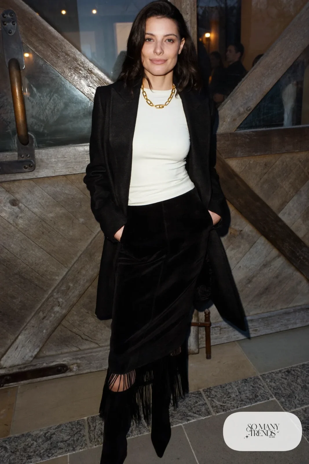 Woman in a black suede fringe-hem skirt with an ivory fitted top and tall boots, western gala outfit 12