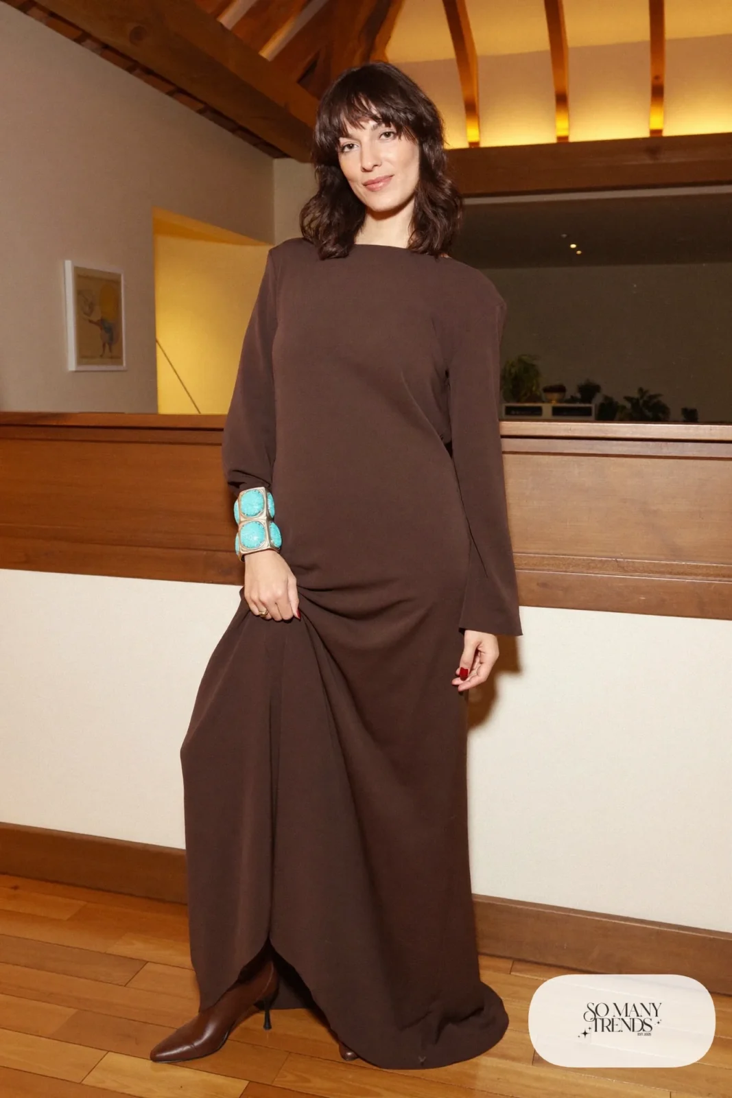 Woman in a chocolate brown crepe gown with a turquoise cuff and brown boots, western gala outfit 21