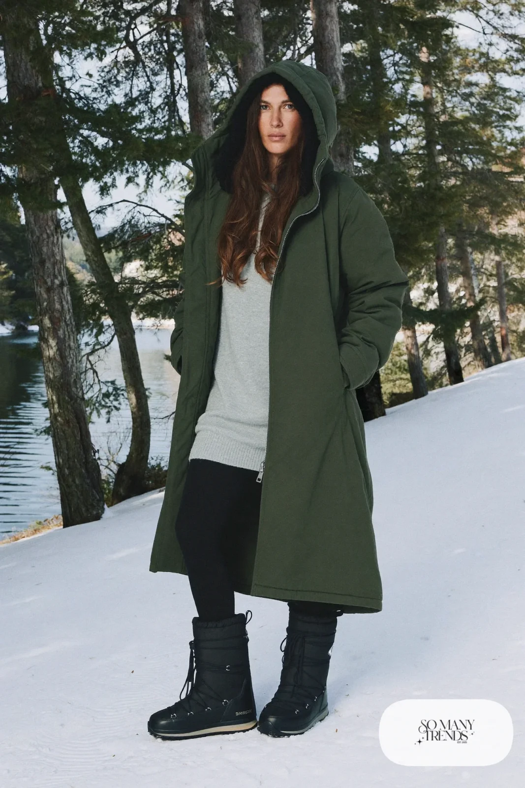 Woman in a forest green parka, oversized gray knit, black fleece leggings and Sorel boots, outfit 4