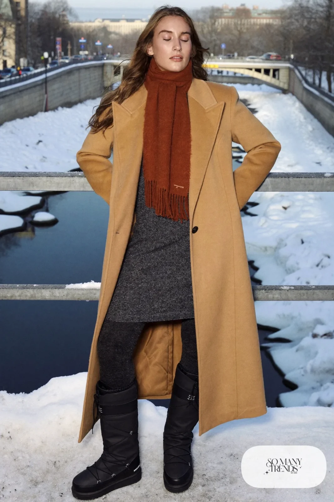 Woman in a charcoal knit midi dress, rust scarf, charcoal tights and black Sorel boots under a camel coat, outfit 6