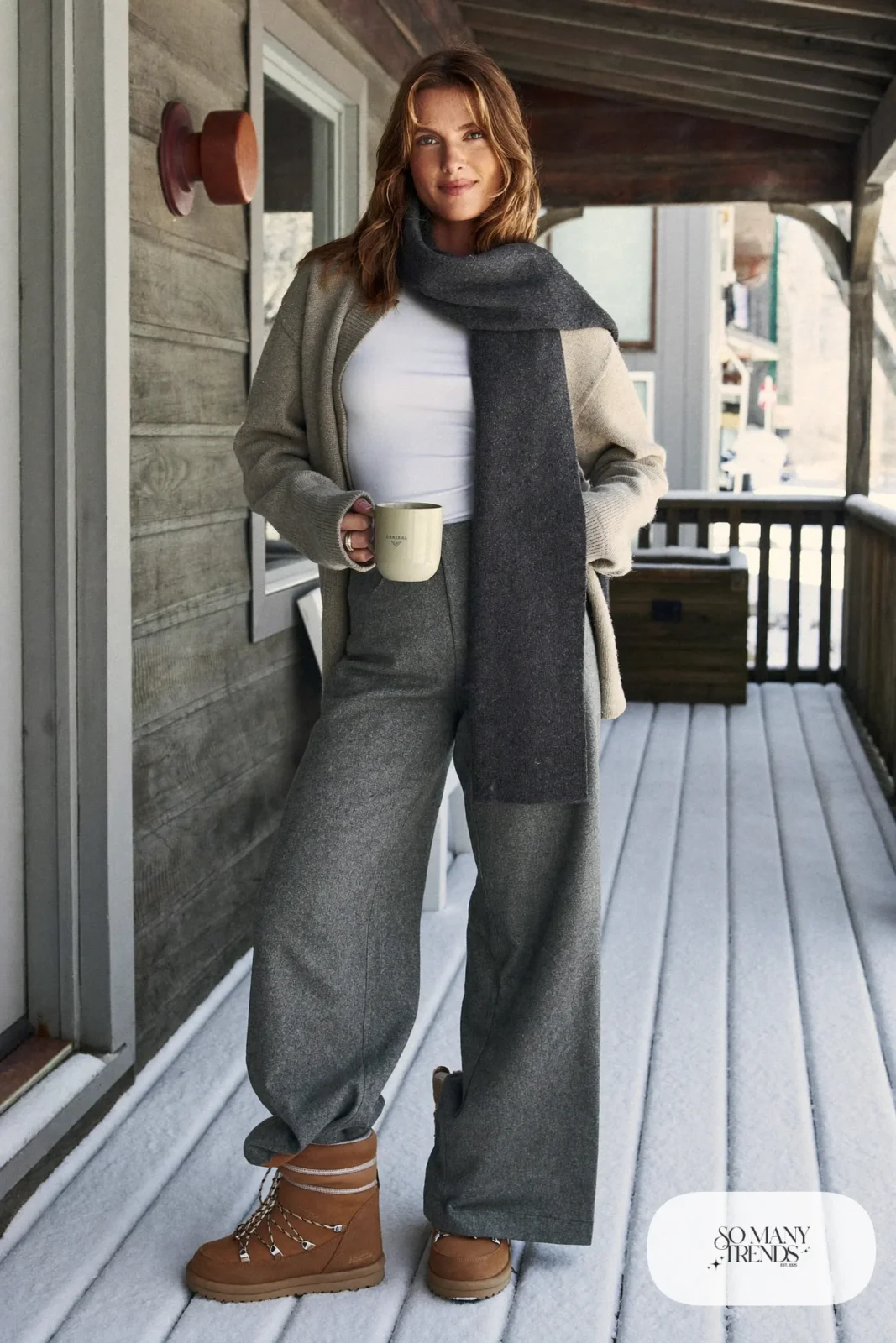 Woman in an oatmeal wool cardigan, gray flannel wide-leg pants, white tee and tan Sorel boots, outfit 14