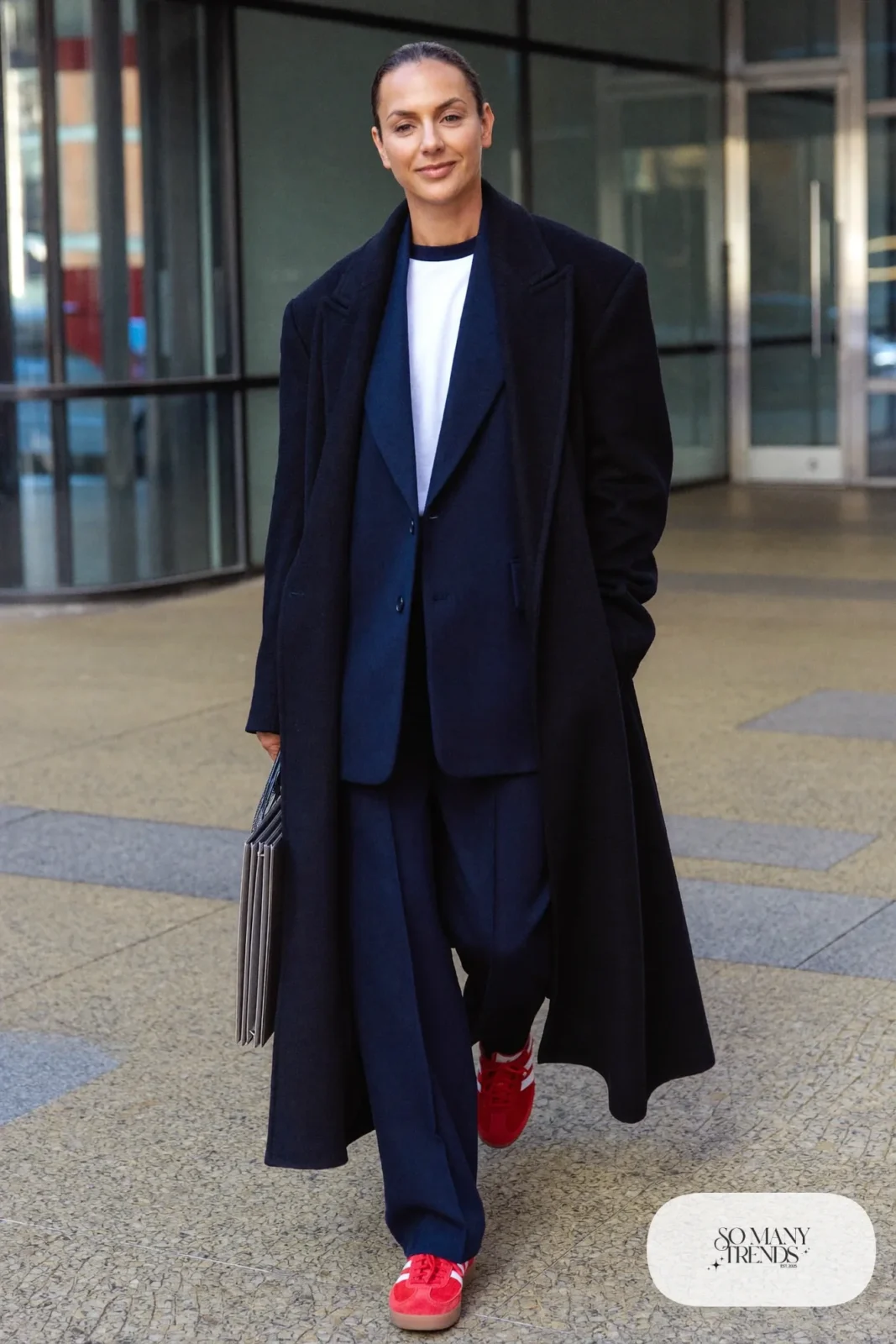 Woman in a navy single-breasted blazer, matching straight pants, white tee and red Adidas Gazelle sneakers, outfit 7