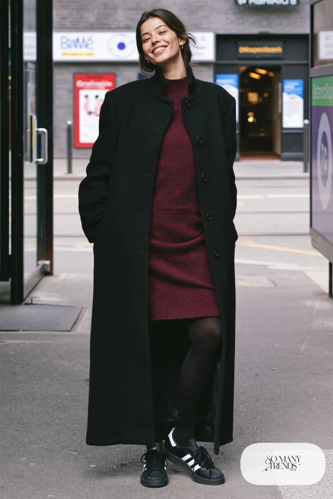 Woman in burgundy knit midi dress, black long coat, black tights and black Adidas Campus sneakers, outfit 5