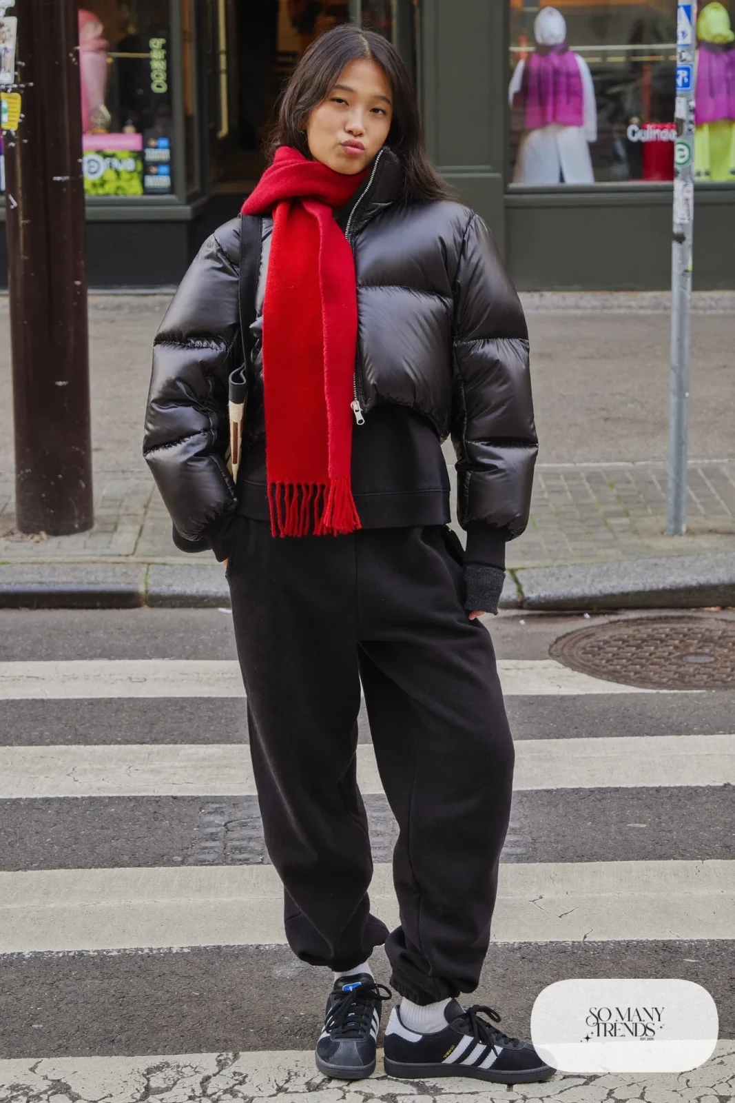 Woman in black puffer jacket, red wool scarf, black joggers and black Adidas Campus sneakers, outfit 12
