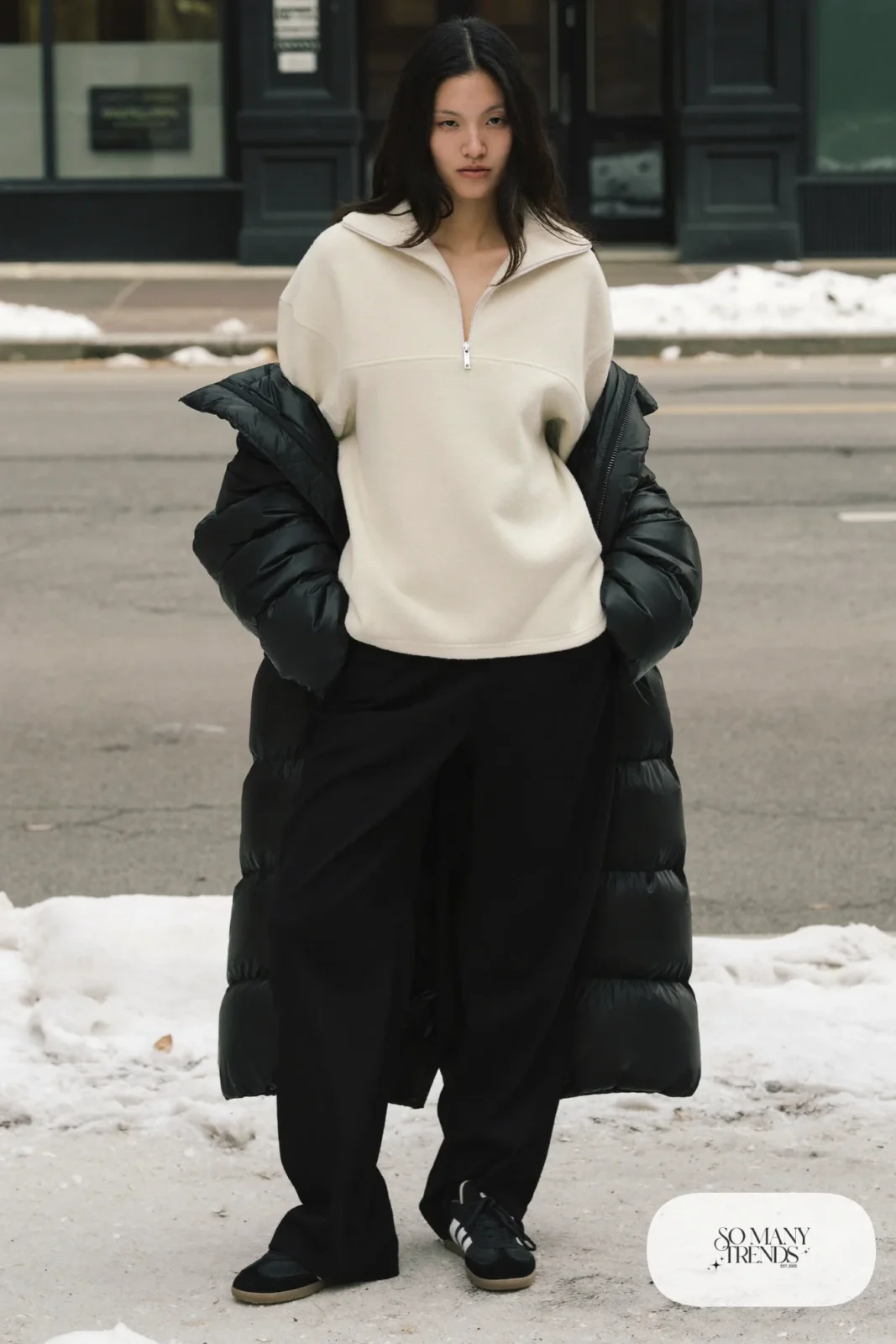 Woman in cream fleece half-zip pullover, black wide pants, black puffer coat and black Adidas Campus sneakers, outfit 21