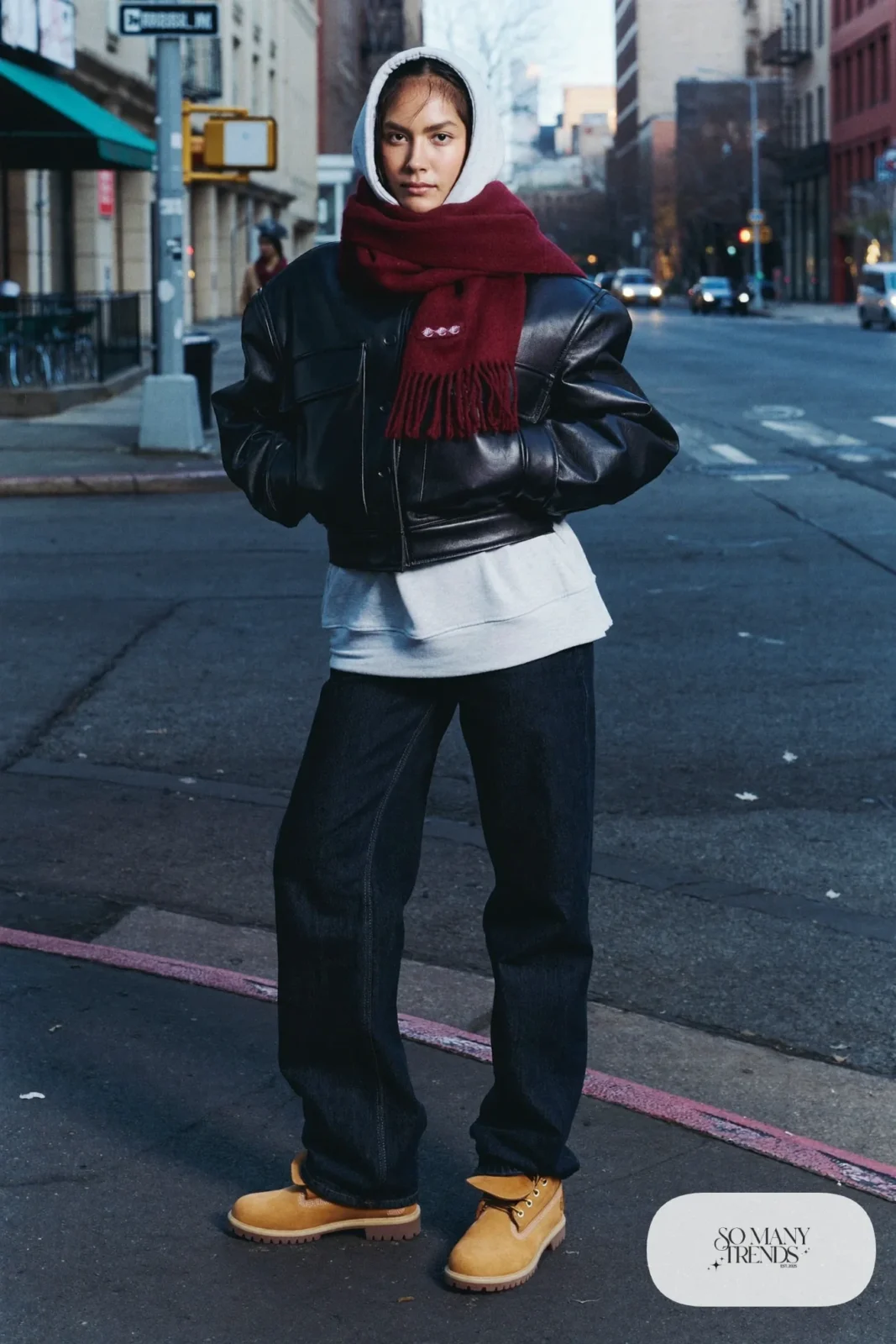 Woman in black leather jacket, gray hoodie, dark jeans and wheat Timberland-style boots, outfit 27