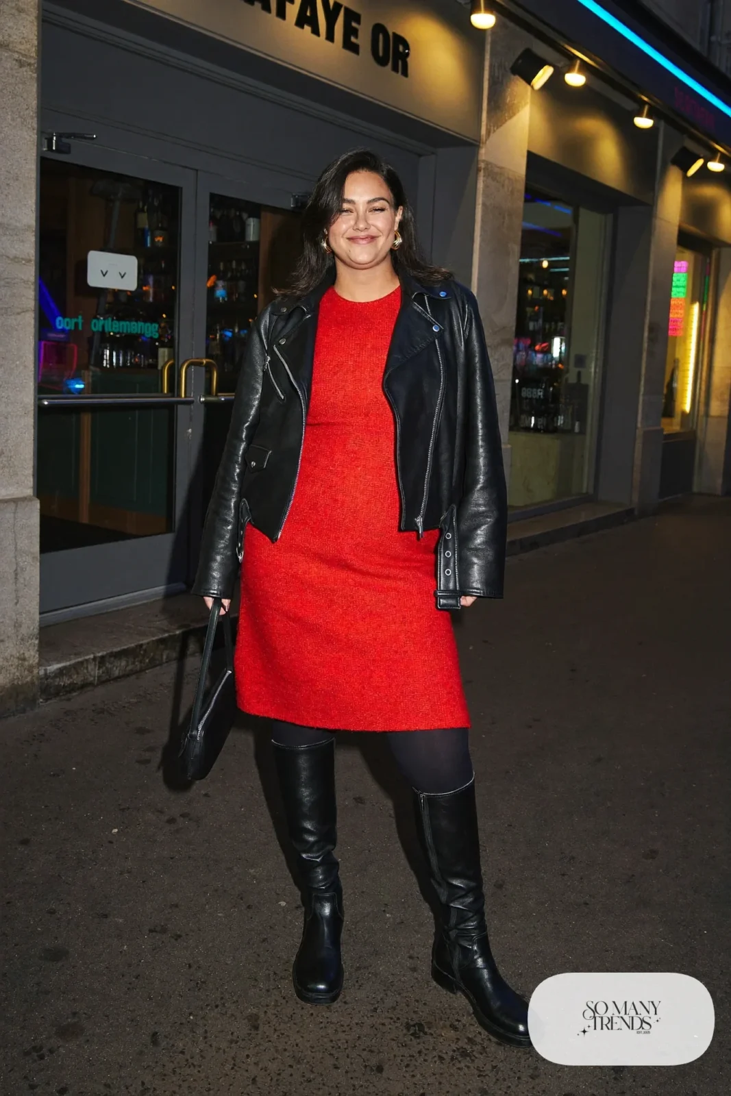 Woman in a red knit midi dress, black biker jacket and tall black boots, look 29
