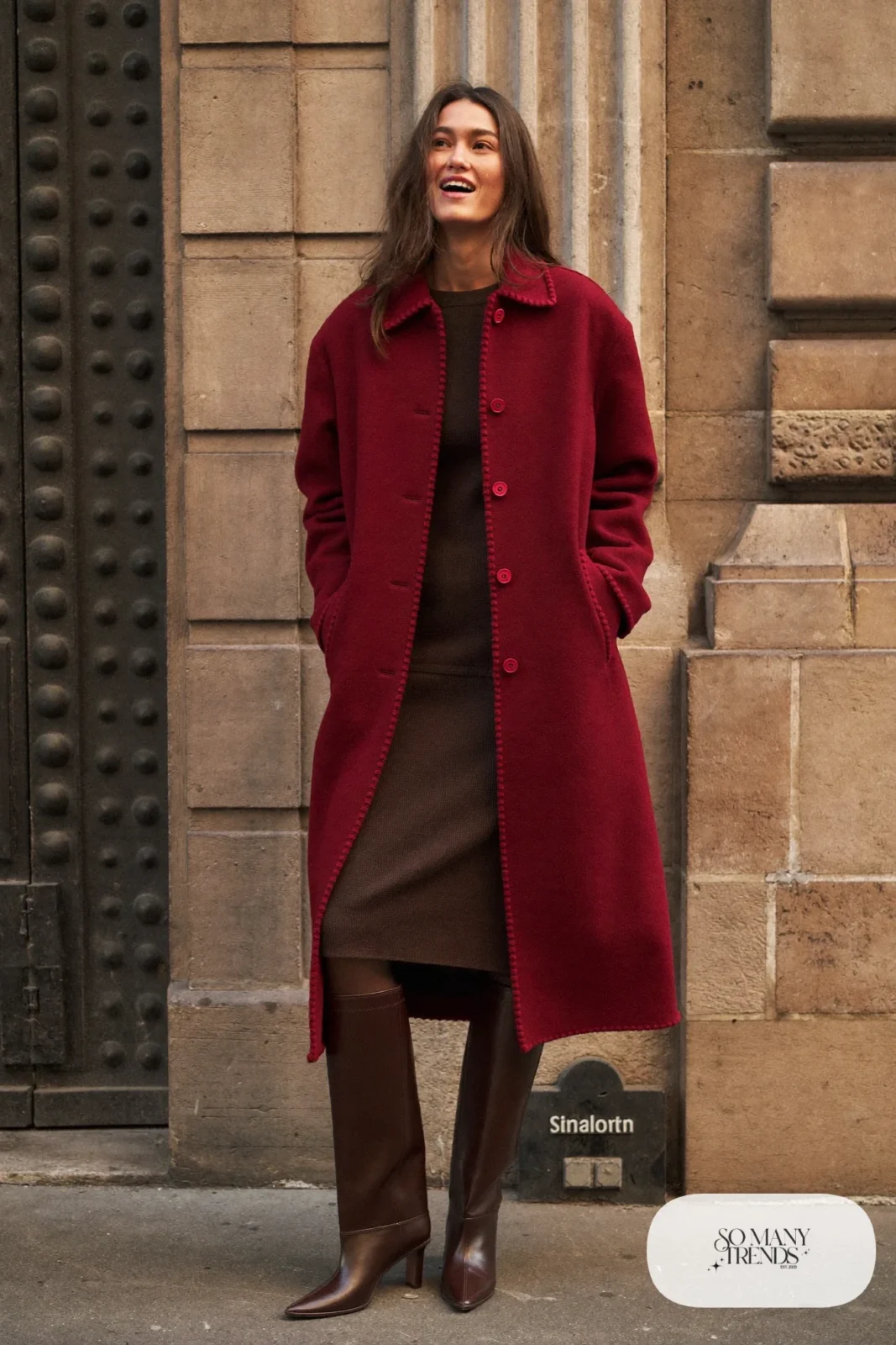 Woman in a burgundy long coat over a chocolate knit midi dress with tall boots, outfit 15
