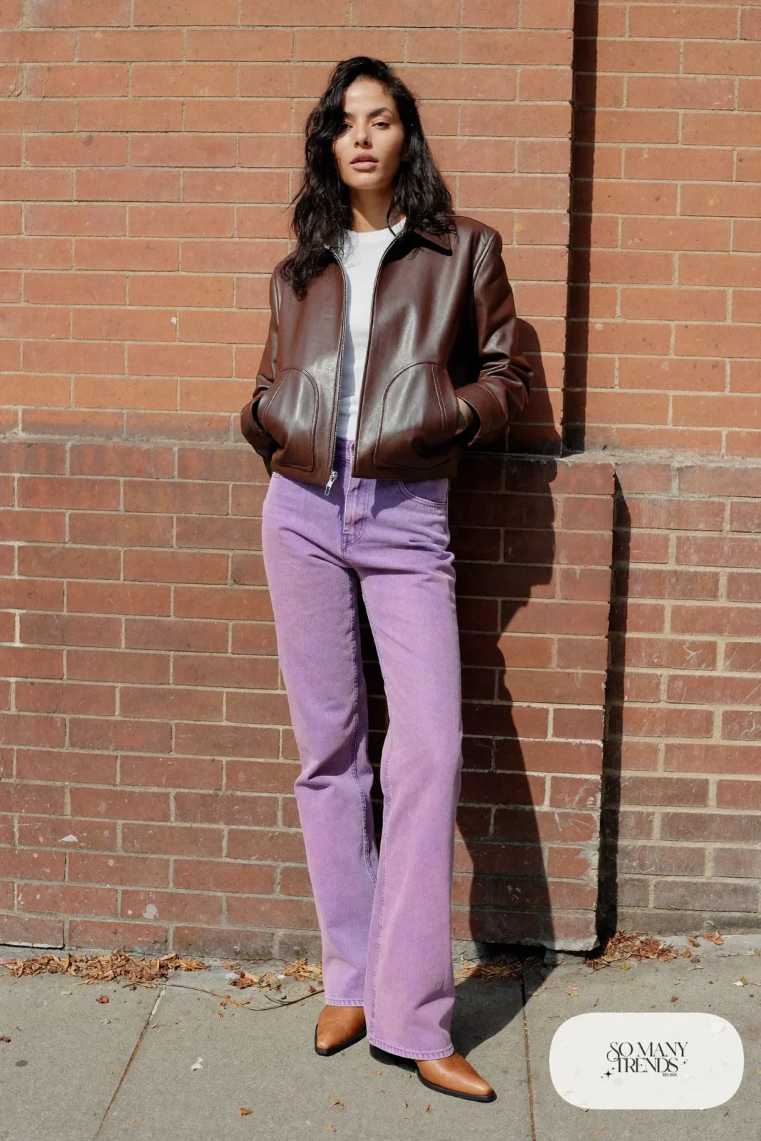 Woman in a chocolate brown leather jacket, white tee, lavender straight-leg jeans and tan leather ankle boots, outfit 4