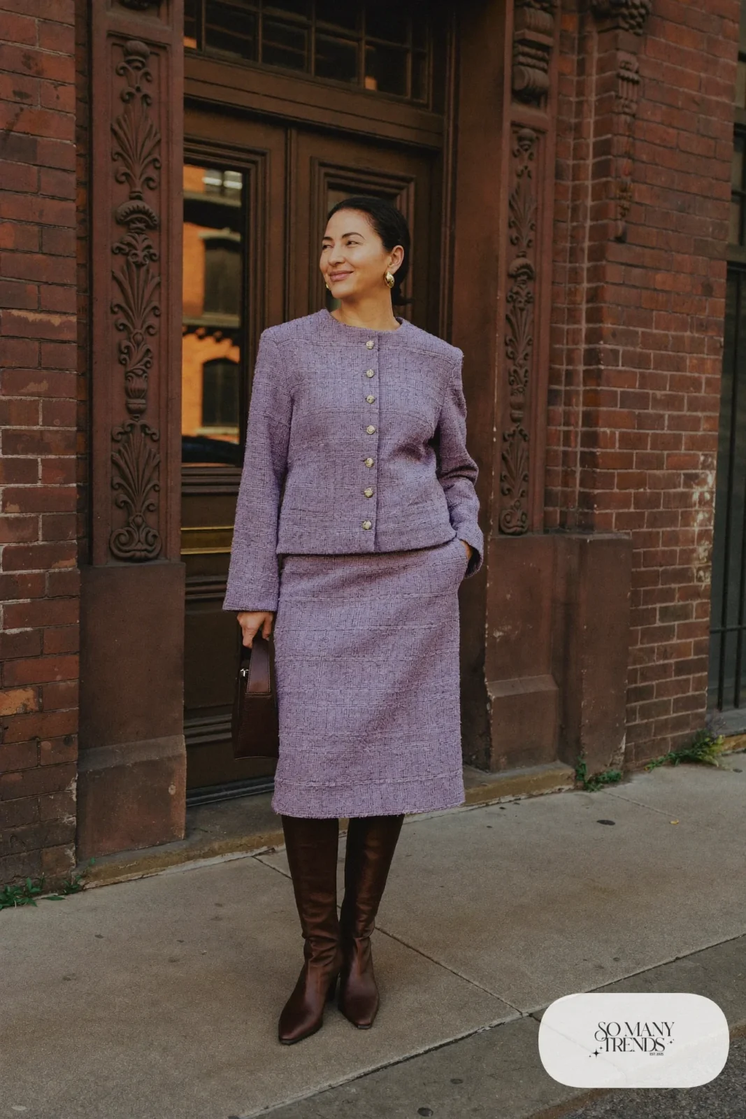 Woman in a lavender tweed boxy jacket and matching midi skirt, sheer black tights and dark brown leather boots, outfit 28