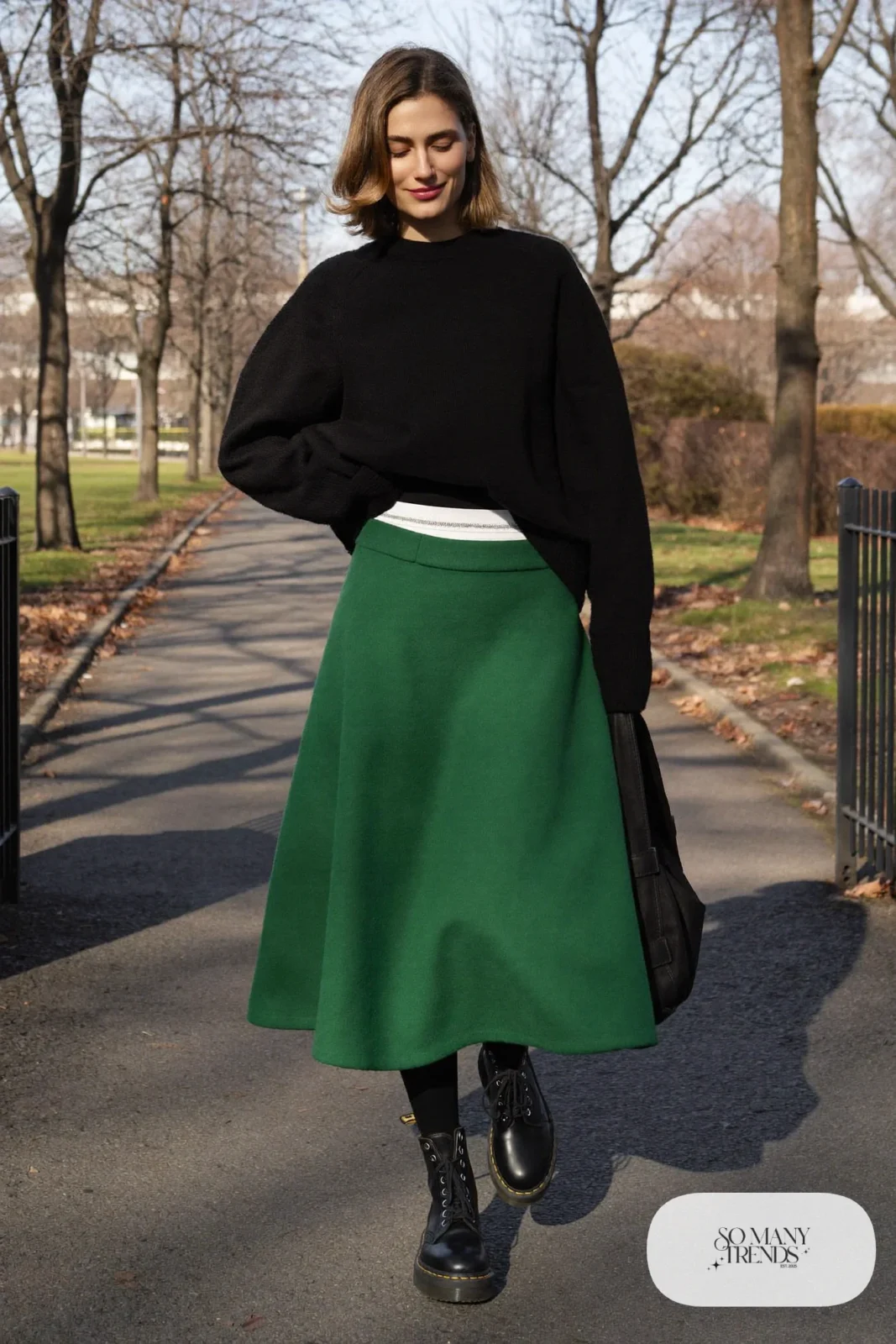 Woman in emerald wool midi skirt, black oversized sweater, black tights and black Doc Martens boots, outfit 8