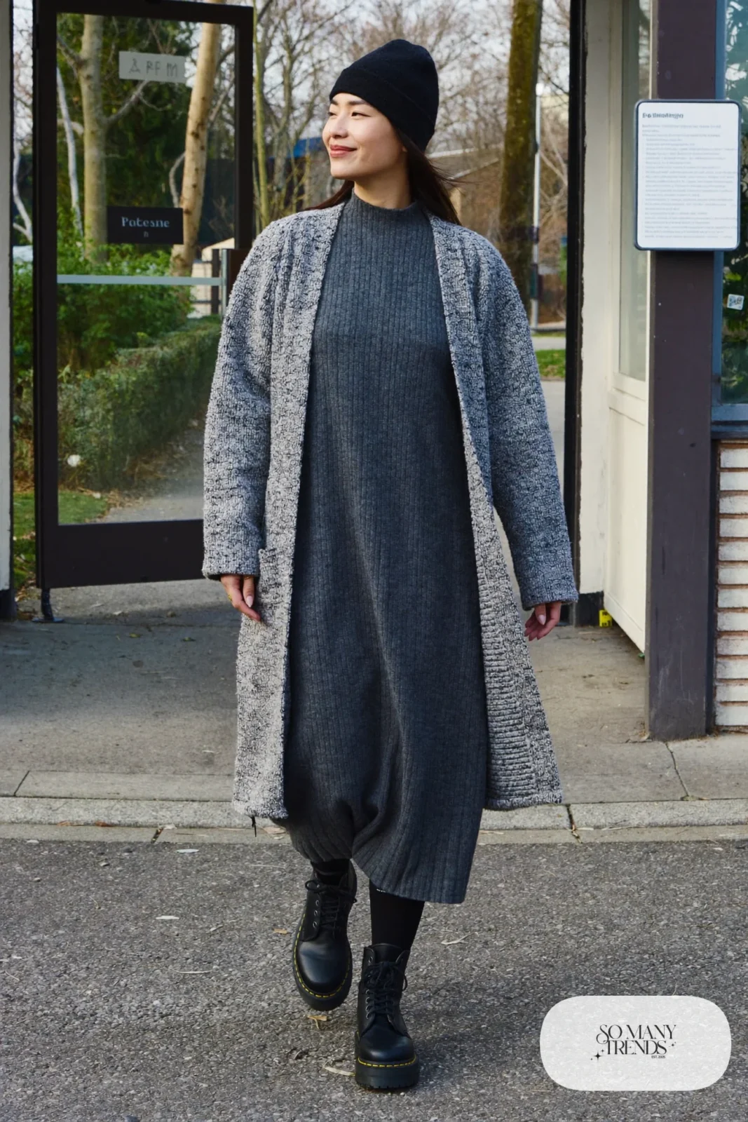 Woman in charcoal knit midi dress, long gray cardigan, opaque black tights, black beanie and black Doc Martens boots, outfit 29