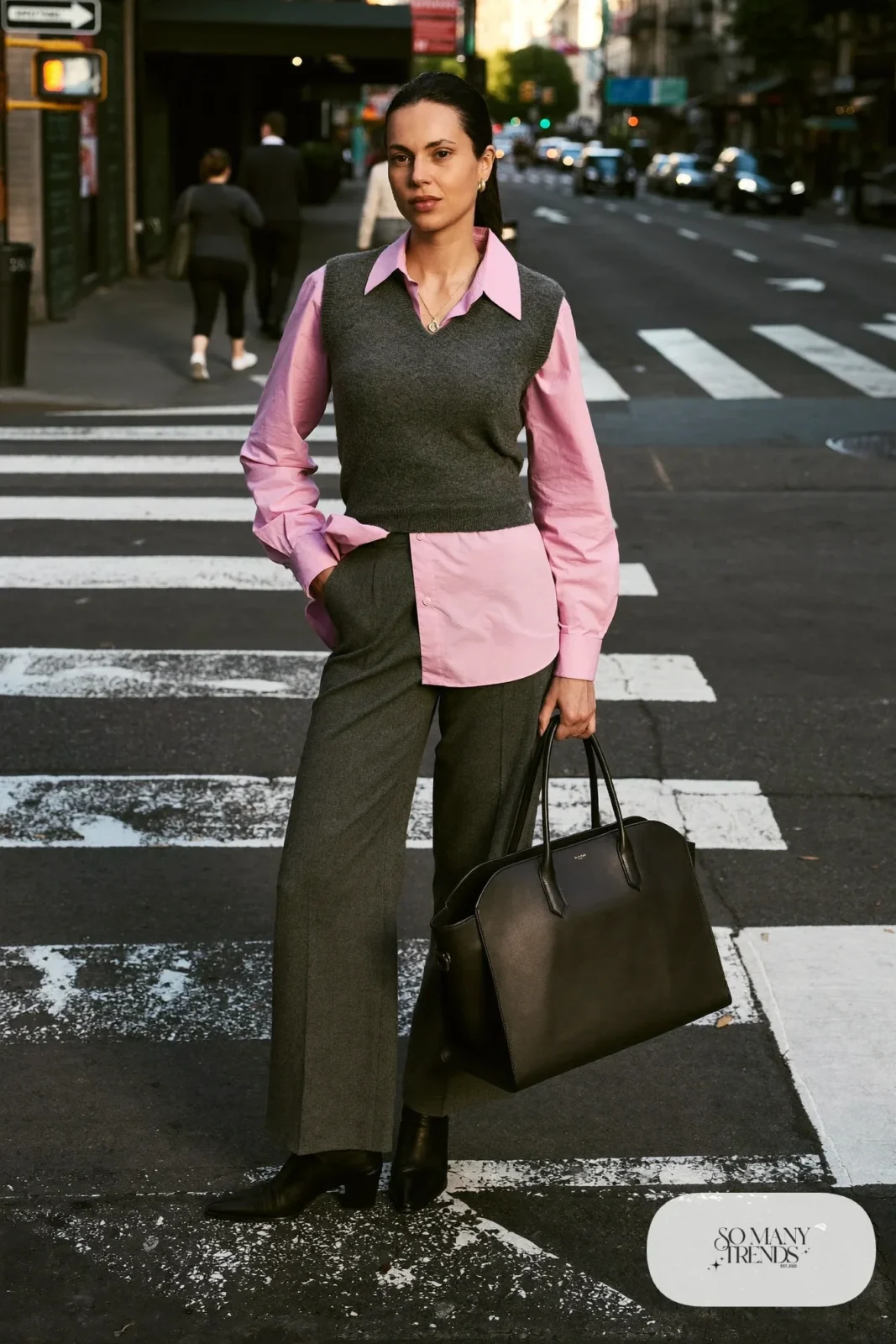 Woman in a rose pink cotton shirt, heather gray wide-leg pants, a dark gray knit vest and black ankle boots, outfit 2