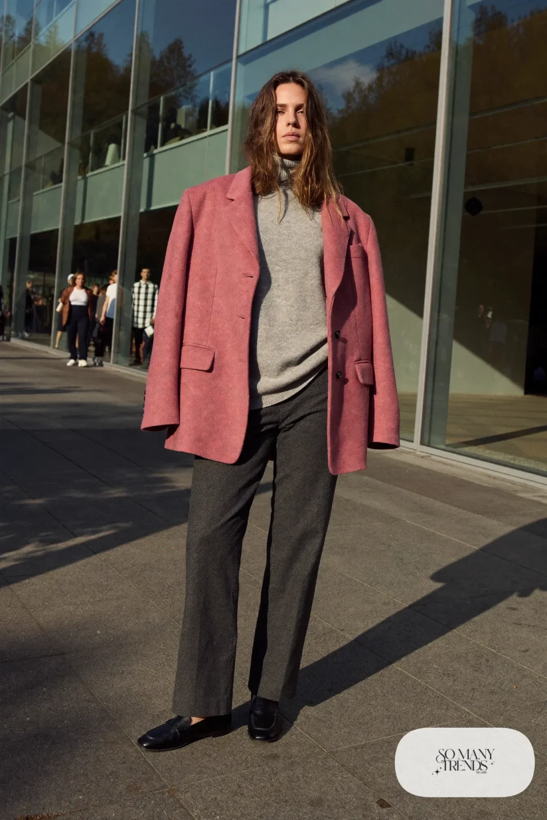 Woman in a rose pink blazer, heather gray turtleneck, charcoal straight pants and black loafers, outfit 4