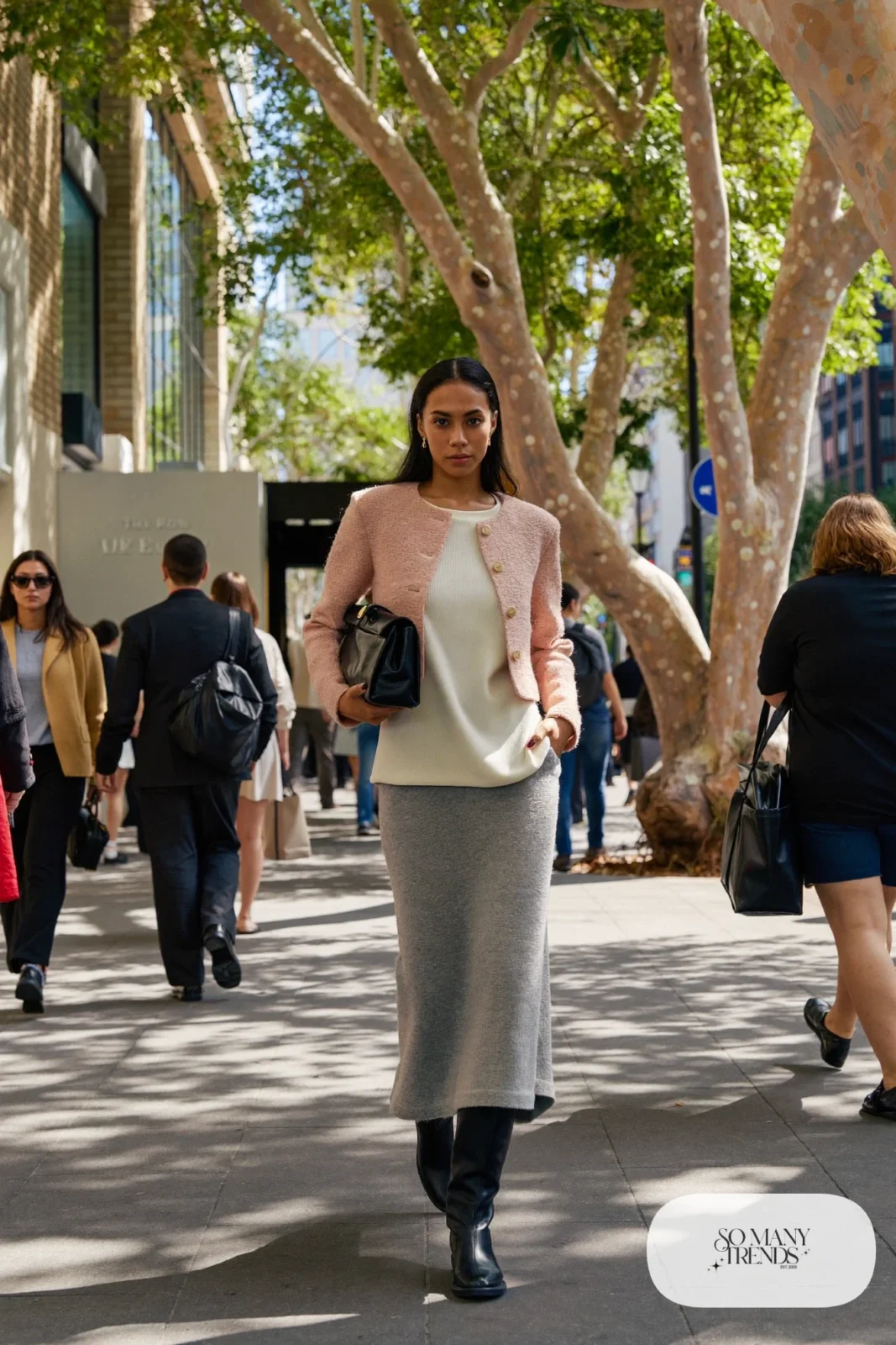 Woman in a short pink bouclé jacket, ivory top, long gray knit maxi skirt and tall black boots, outfit 20