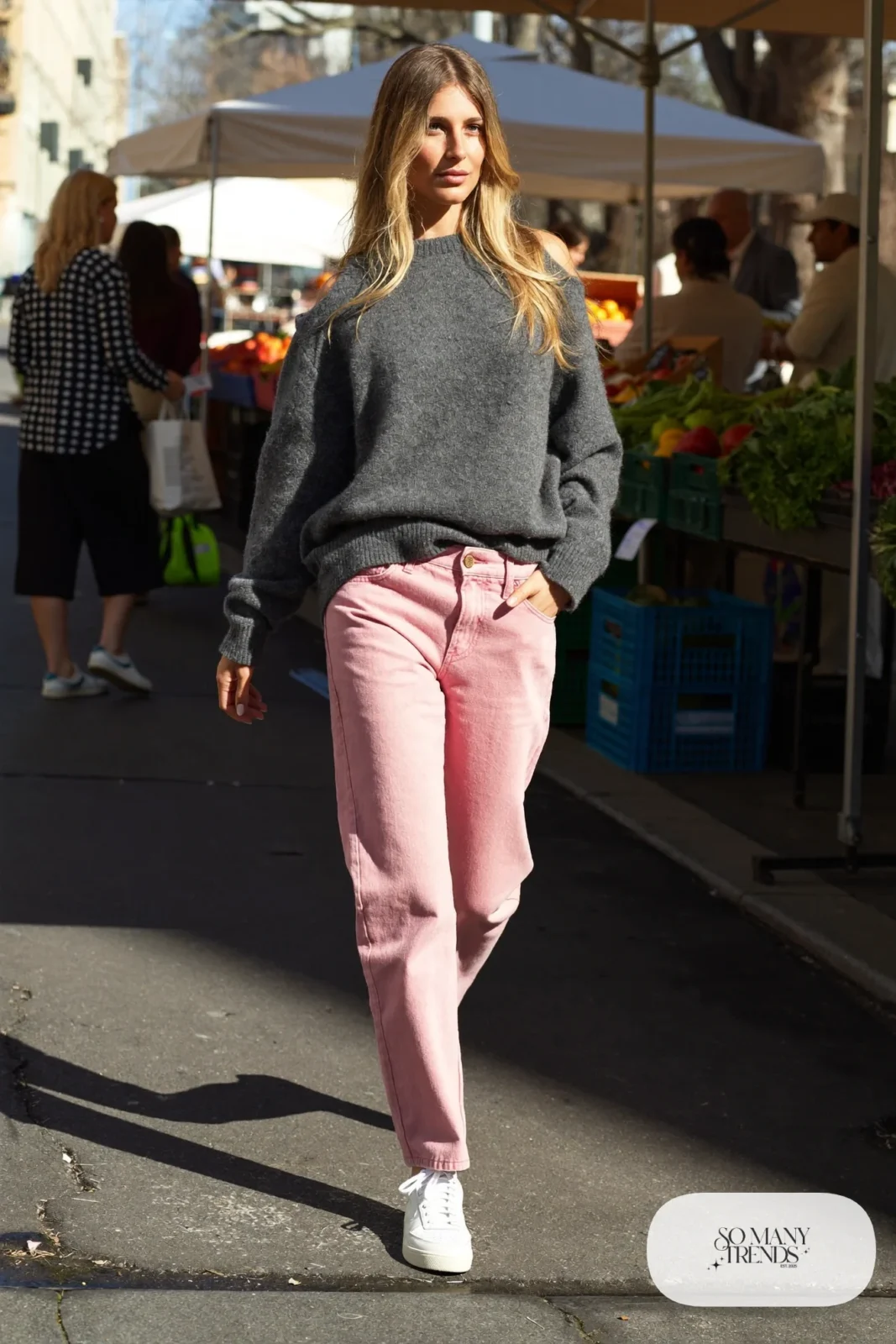 Woman in an oversize heather gray sweater, rose pink straight jeans and white sneakers, outfit 7