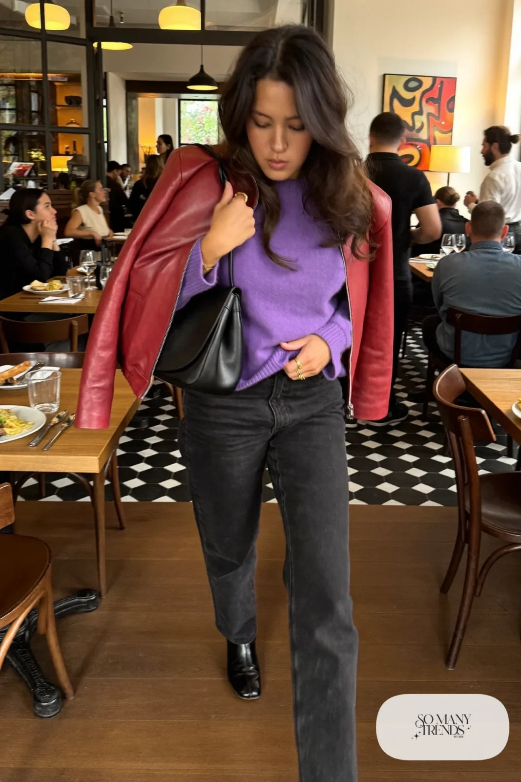 Woman in a wine red faux leather short jacket, violet knit sweater, black straight jeans and black boots, look 17