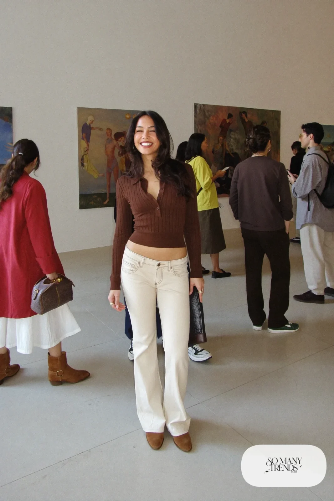 Woman in a fitted chocolate knit polo, low-rise ecru flare jeans and brown suede ankle boots, look 19