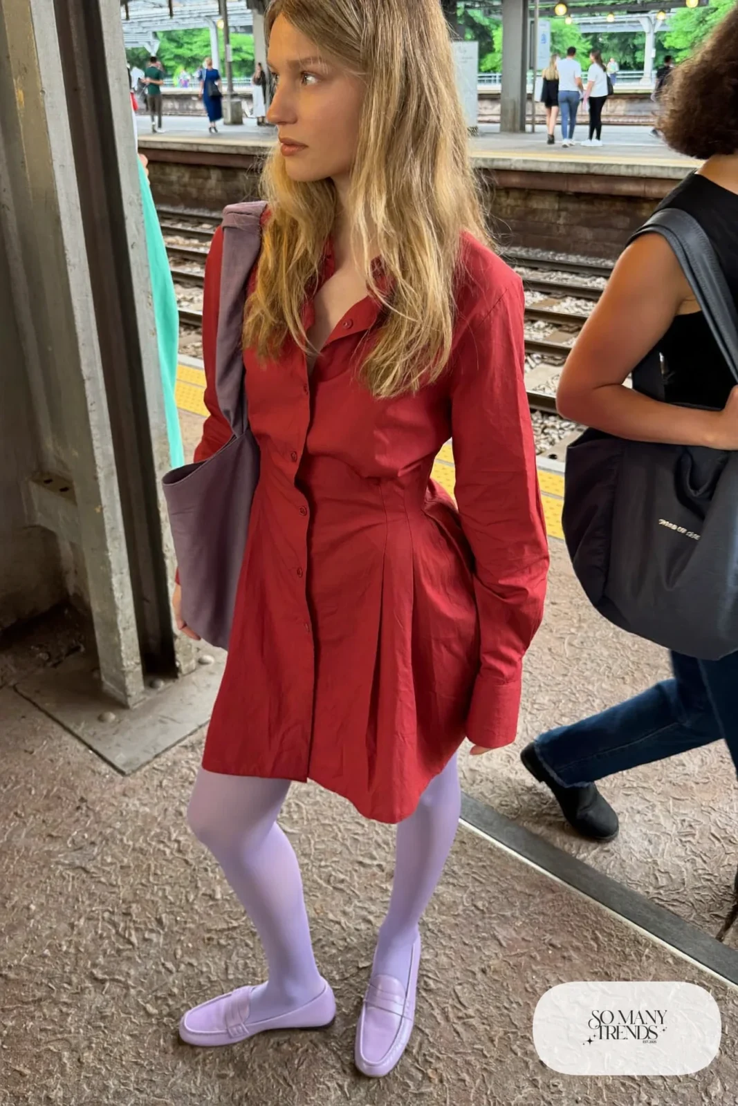 Woman in a tomato red knee-length shirt dress, lilac opaque tights and lilac loafers, look 7