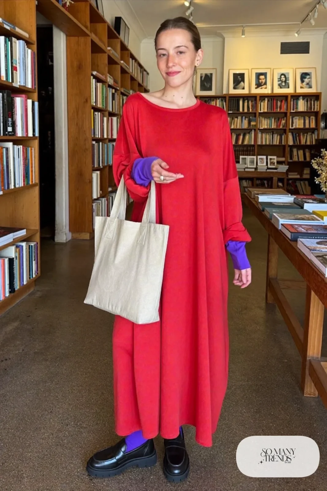 Woman in a loose tomato red knit maxi dress, violet opaque tights and black loafers, look 21