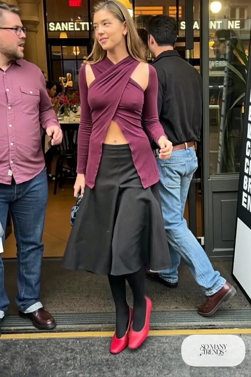 Woman in a plum cross-front long-sleeve top, black midi skirt and red heels, look 27